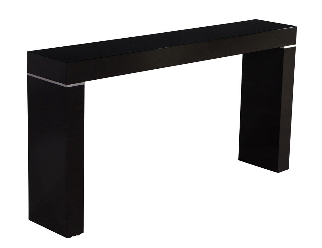 Vaughan Benz Style Ebonized Console Table with Silver Trim. America, circa 1960’s. Sleek modern styling with silver trim accents. Newly restored in a high gloss polished black lacquer. Perfect for hallways, entrances and sofas. Priced individually
