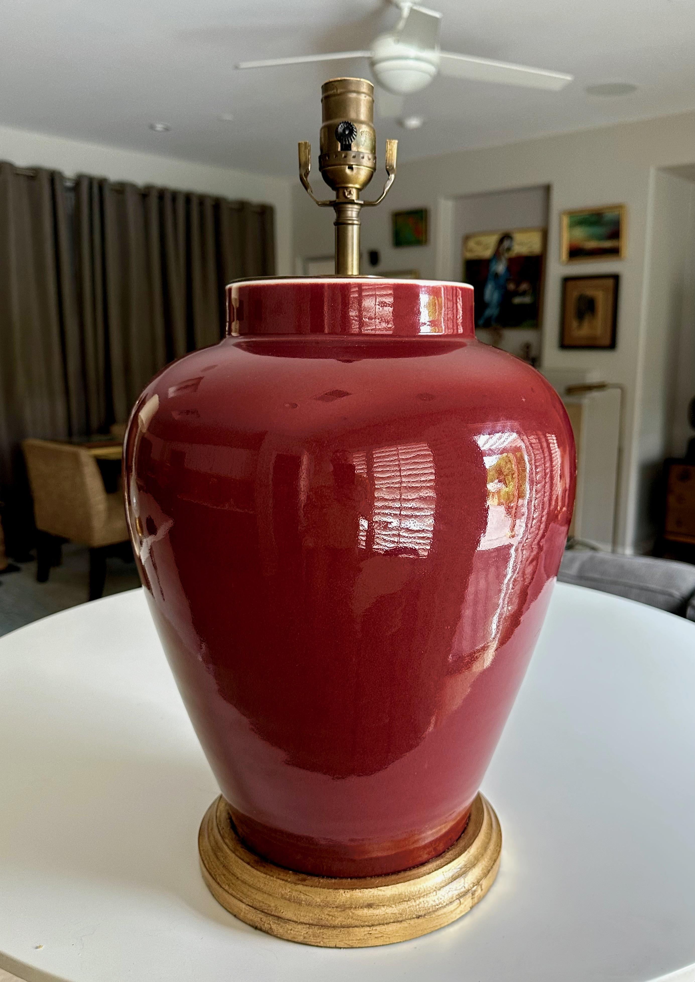Single Chinese Asian Sang de Boeuf oxblood porcelain vase mounted on gilt wood lamp base by renowned Vaughan Designs Lighting. 
Measures: Height top of socket 20.5
