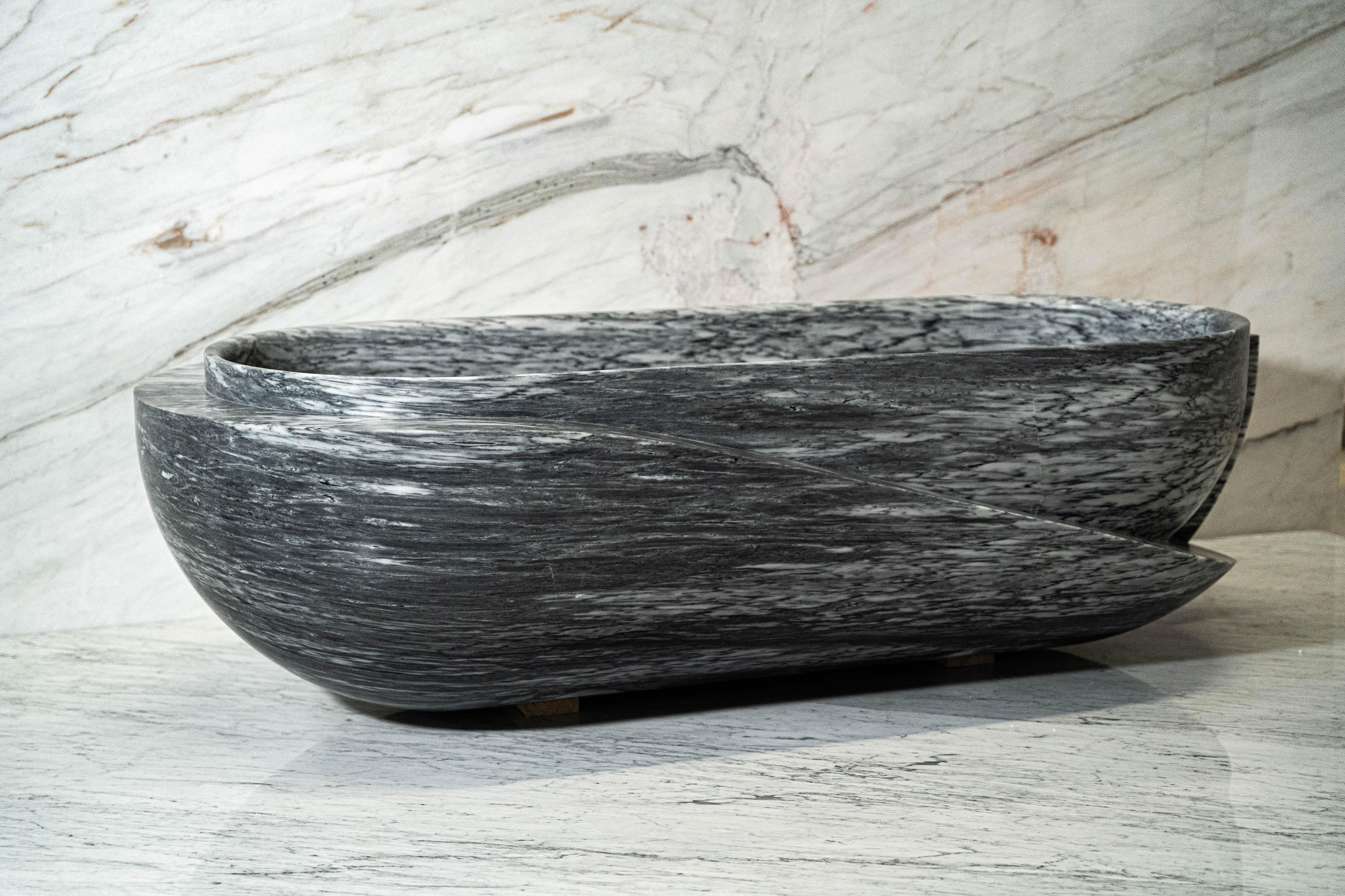 Realized in Azul Lagoa stone, this sculptural bath embodies a sensual reduction of form. The design transforms the heavy stone with a beguiling levity. Inspirations draw from a dreamlike interpretation of the past from the perspective of the