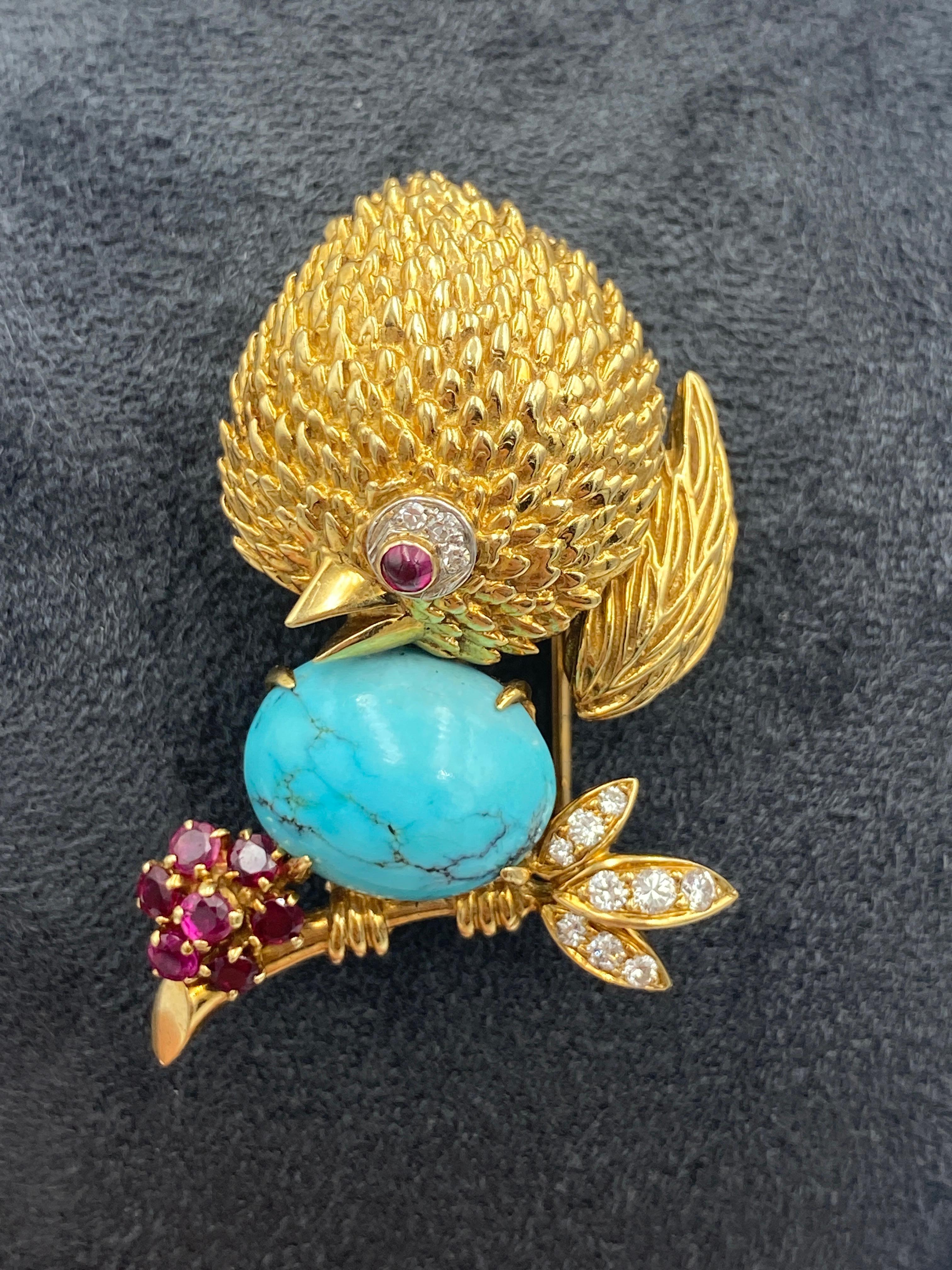 Cette ravissante broche en or 18 carats, réalisée dans les années 1960, est ornée de petits diamants et rubis de taille ronde et d'une grande turquoise cabochon en guise d'œuf. Il s'agit d'un excellent complément à toute collection.