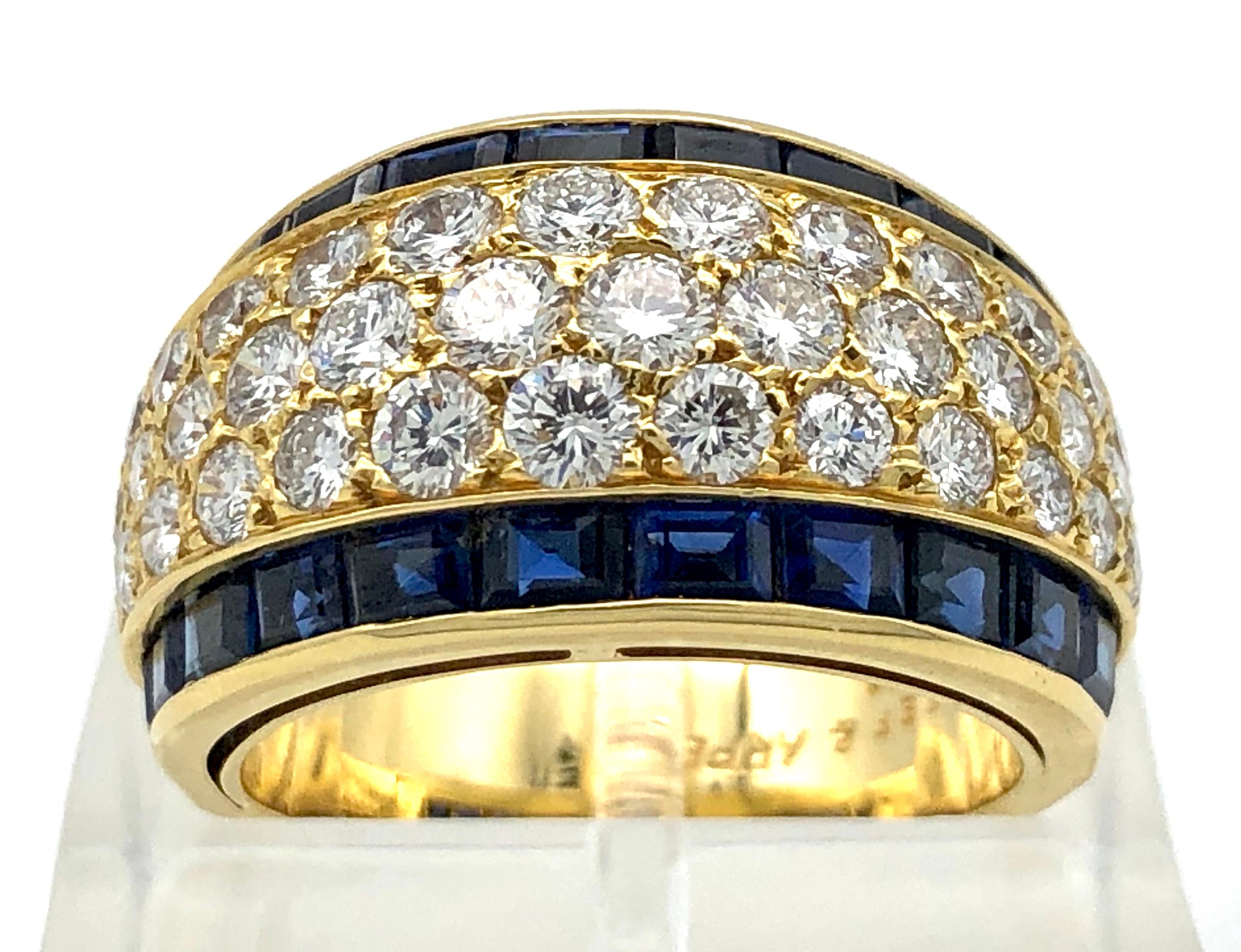 This beautiful, slightly domed sapphire and diamond band ring by Van Cleef & Arpels is fully signed and numbered on the inside of the shank.  The outside of the wide gold band is stamped with the french control mark for 18k. Three rows of brilliant