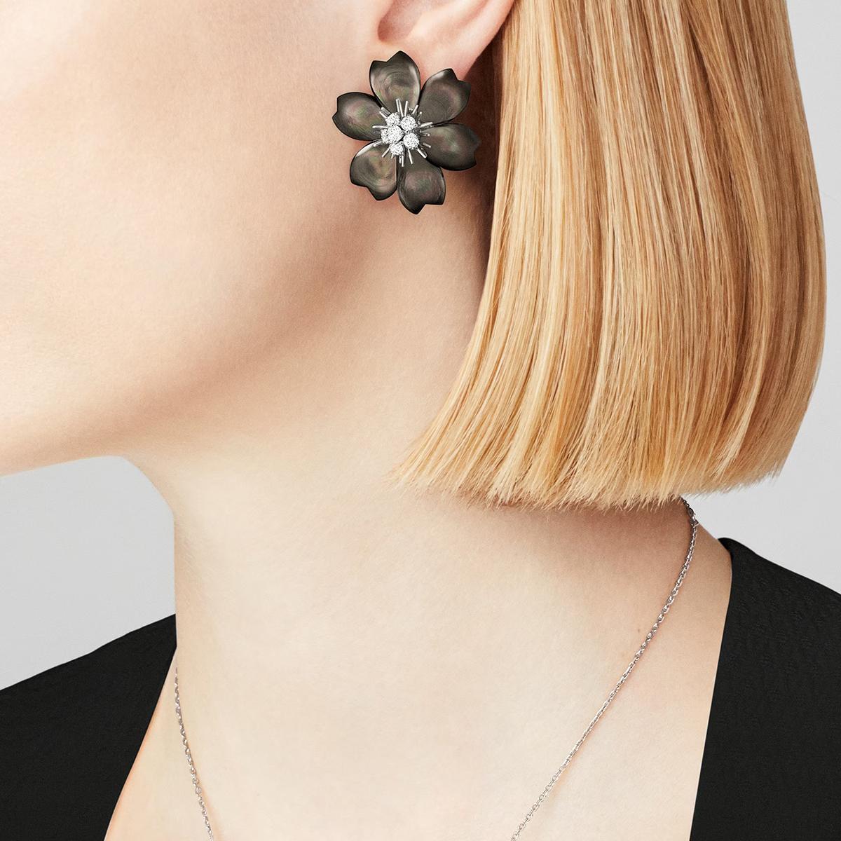Van Cleef & Arpels Orecchini a clip in oro bianco 18 carati con MOP nero 'Rose de Noel' (medio). Gli orecchini presentano un design floreale con 12 petali di madreperla nera e centri in oro bianco 18 carati e diamanti. Ci sono 12 diamanti rotondi