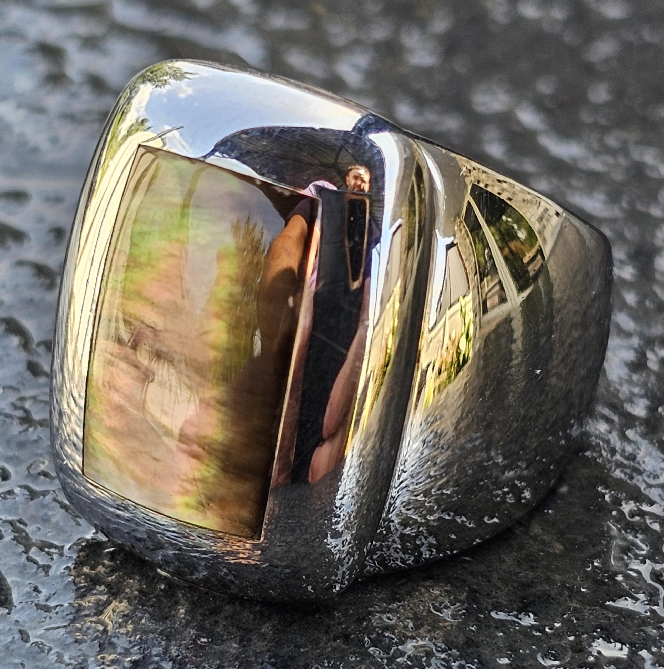 Voici une bague Van Cleef & Arpels en or blanc 18 carats, au design audacieux, ornée d'une pierre rectangulaire irisée. La bague est de taille 6,25 et présente une finition élégante et polie. La surface de la pierre présente un jeu de couleurs