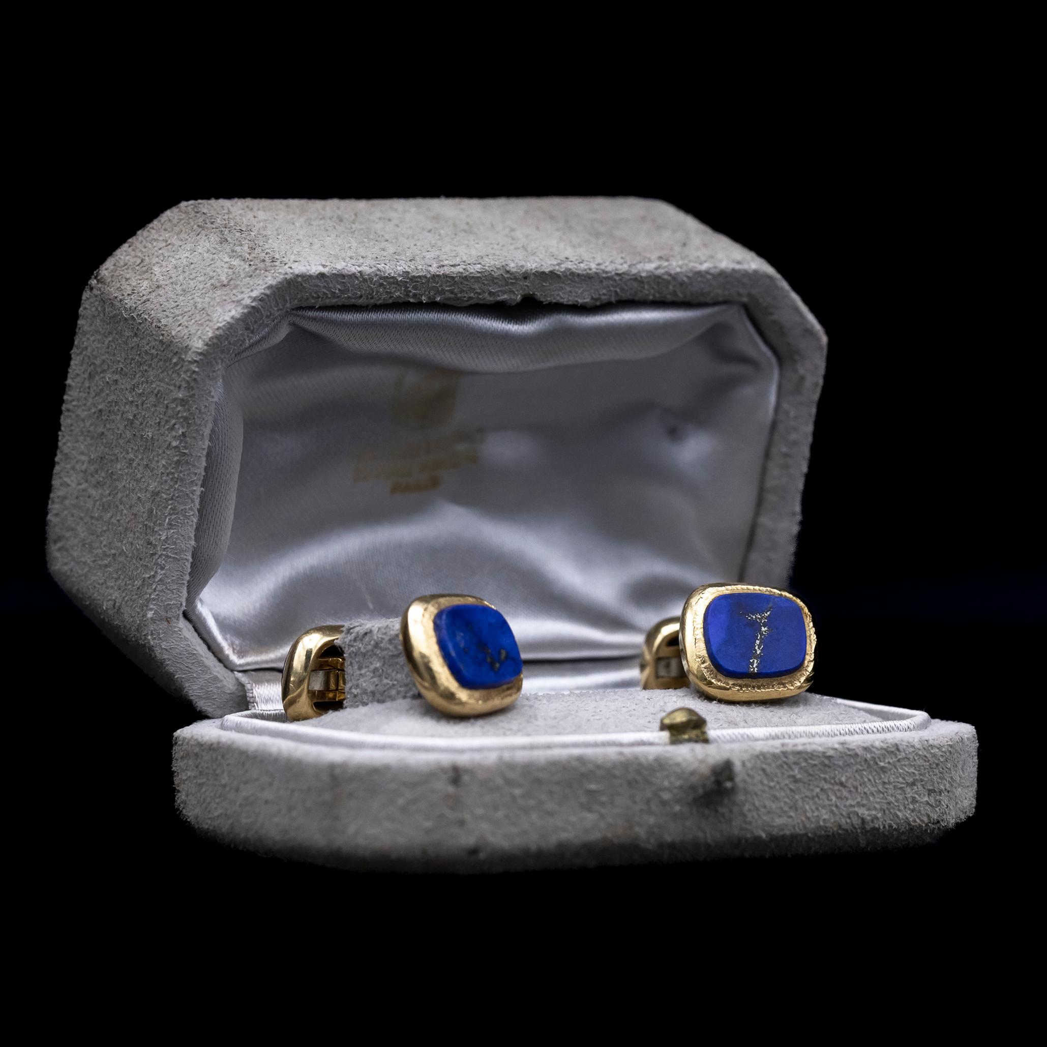 Van Cleef & Arpels presents an exquisite pair of cufflinks crafted by the skilled hands of Georges Lenfant in 18kt yellow gold, originating from France circa 1967. Each cufflink boasts two asymmetrical cushion-shaped plaques, intricately textured in