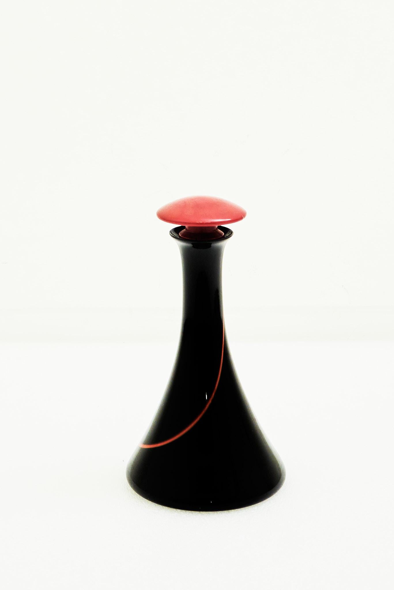 Murano-Glasflasche mit Stopfen, Venedig

Diese elegante Murano-Glasflasche mit Stopfen zeigt die raffinierte Handwerkskunst der venezianischen Glasbläser. Mit ihren zarten, langgestreckten Formen und komplizierten Details sind diese Flaschen ein