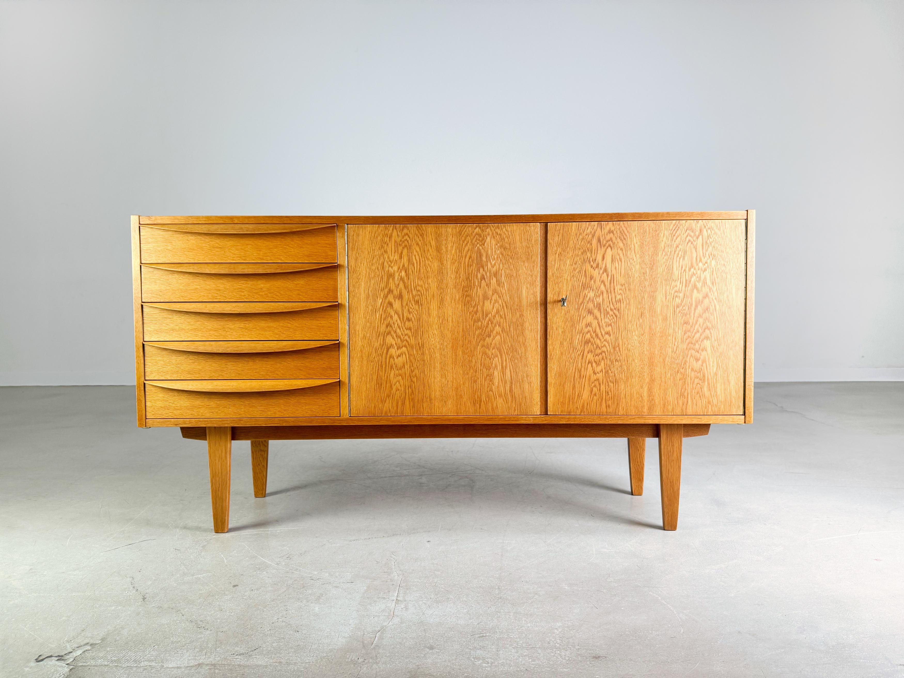 Wir bieten ein wunderschönes Sideboard von VEB DW Hellerau aus der beliebten Serie 602 zum Verkauf an. Das Design stammt vom Bauhausschüler Franz Ehrlich, der für seine klaren Linien und funktionalen Möbel bekannt ist und zeichnet sich durch seine