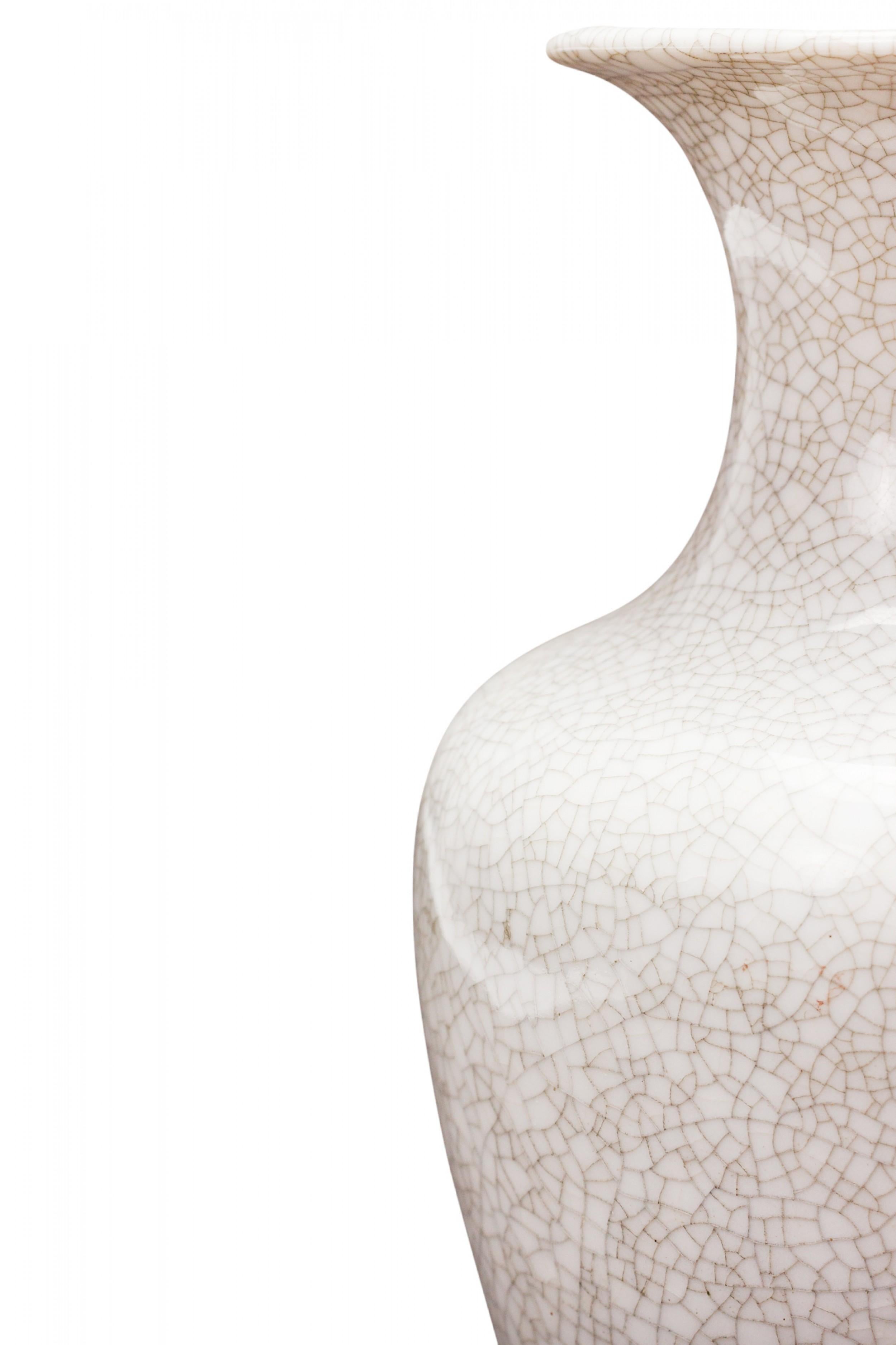 Vaso in ceramica della metà del secolo scorso dalla forma affusolata e arrotondata, con collo stretto e apertura svasata, rifinito con uno smalto bianco crepla. (marchio sul fondo, LICHTE VEB)

Condit: Buono; Usura coerente con l'età e l'utilizzo