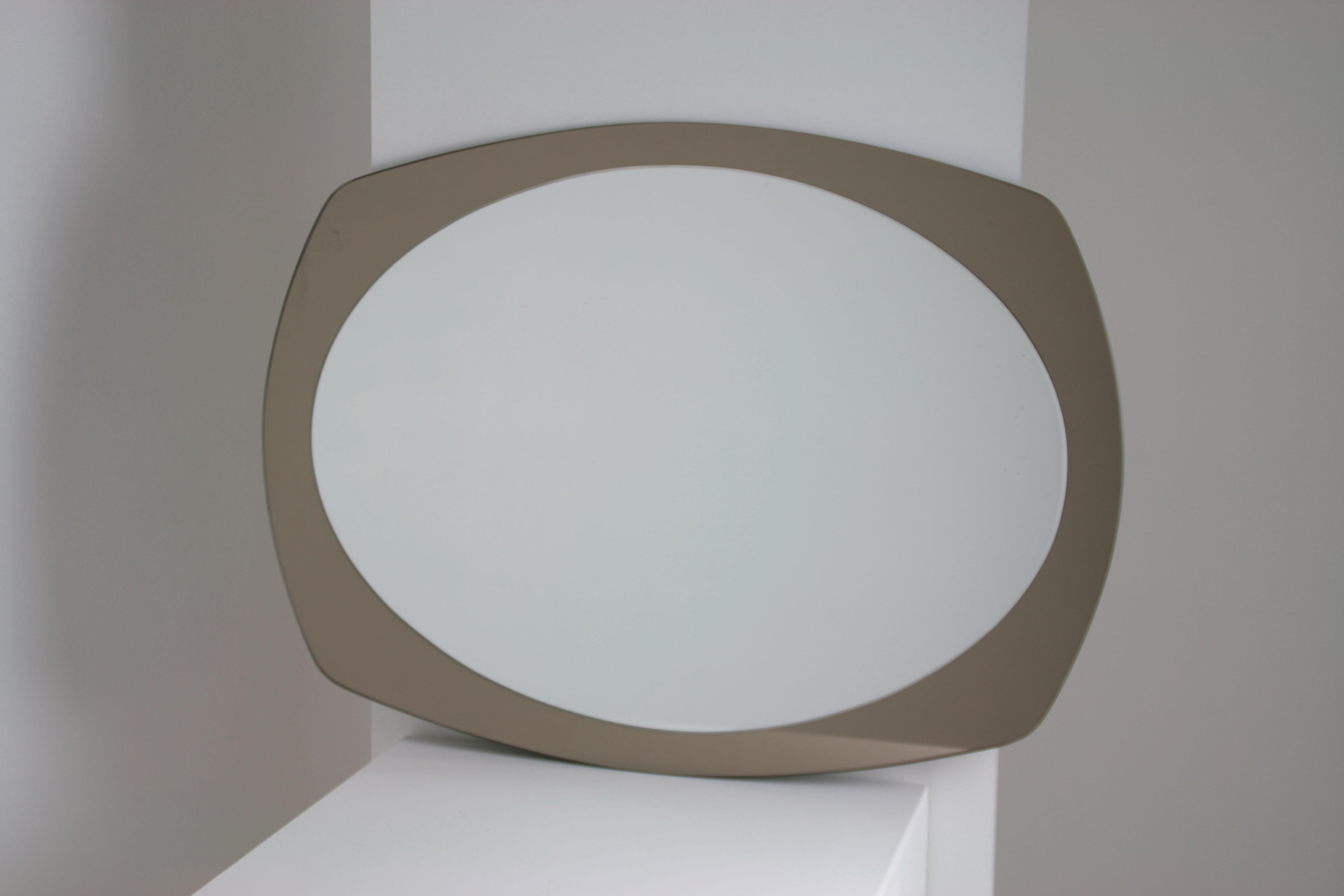 Miroir ovale produit par Veca en Italie dans les années 1960. Cadre en verre fumé. Excellent état. Pas de brillance. Il peut être installé verticalement ou horizontalement. Dimensions : l80 x l60 cm.