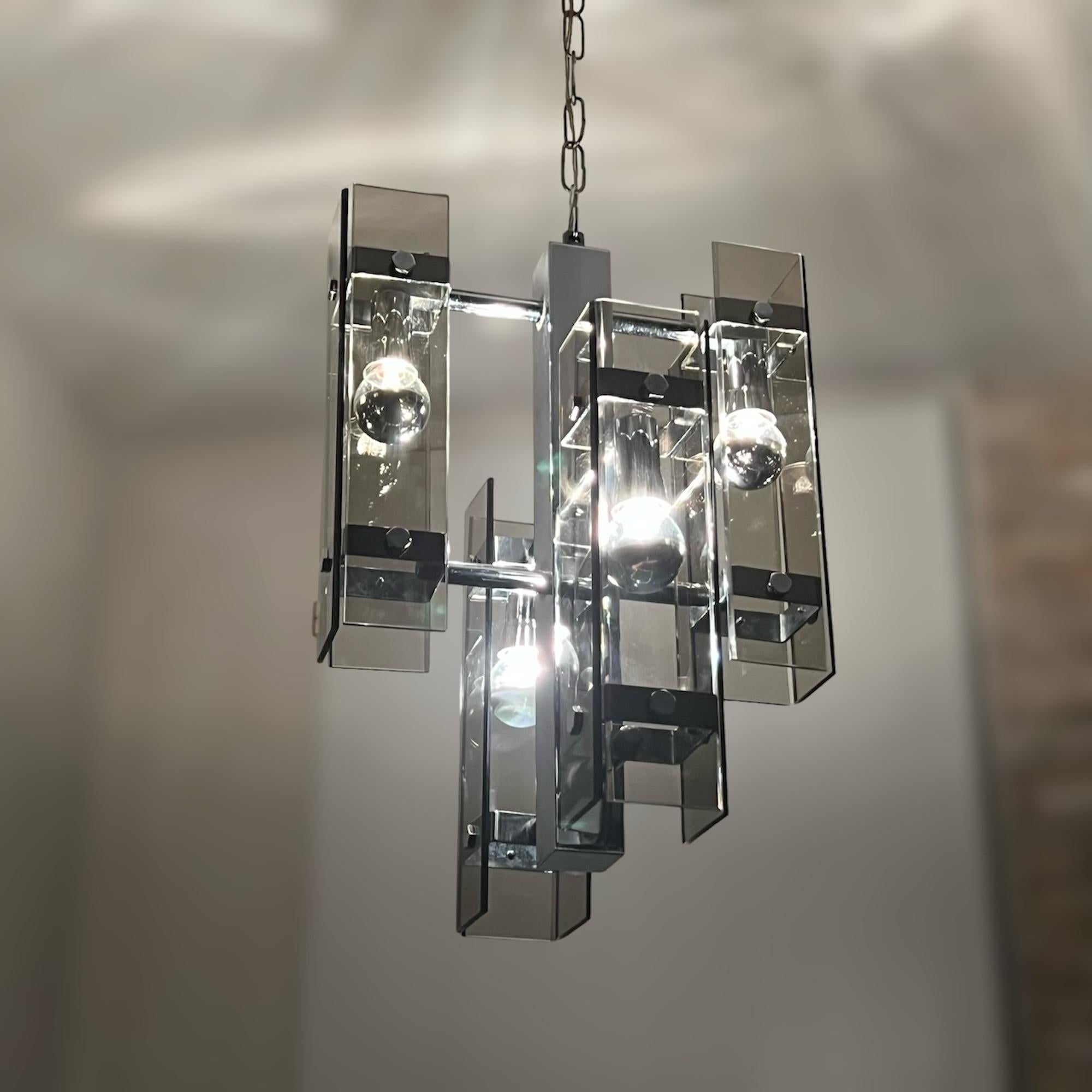 Embrace the charm of 70s style with this Vintage Hanging Lamp by Veca, expertly crafted in Italy. This large and sculptural lamp, featuring four lights, showcases a stunning combination of shining chrome metal and smoke grey glass, creating a visual