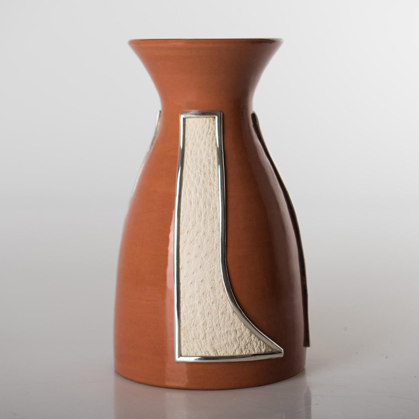 A sublime blend of first-rate materials deftly handcrafted following traditional methods, this gorgeous vase is fashioned of polished earthenware and enriched with precious ostrich leather details complete with a silver 925 frame. Customizable upon