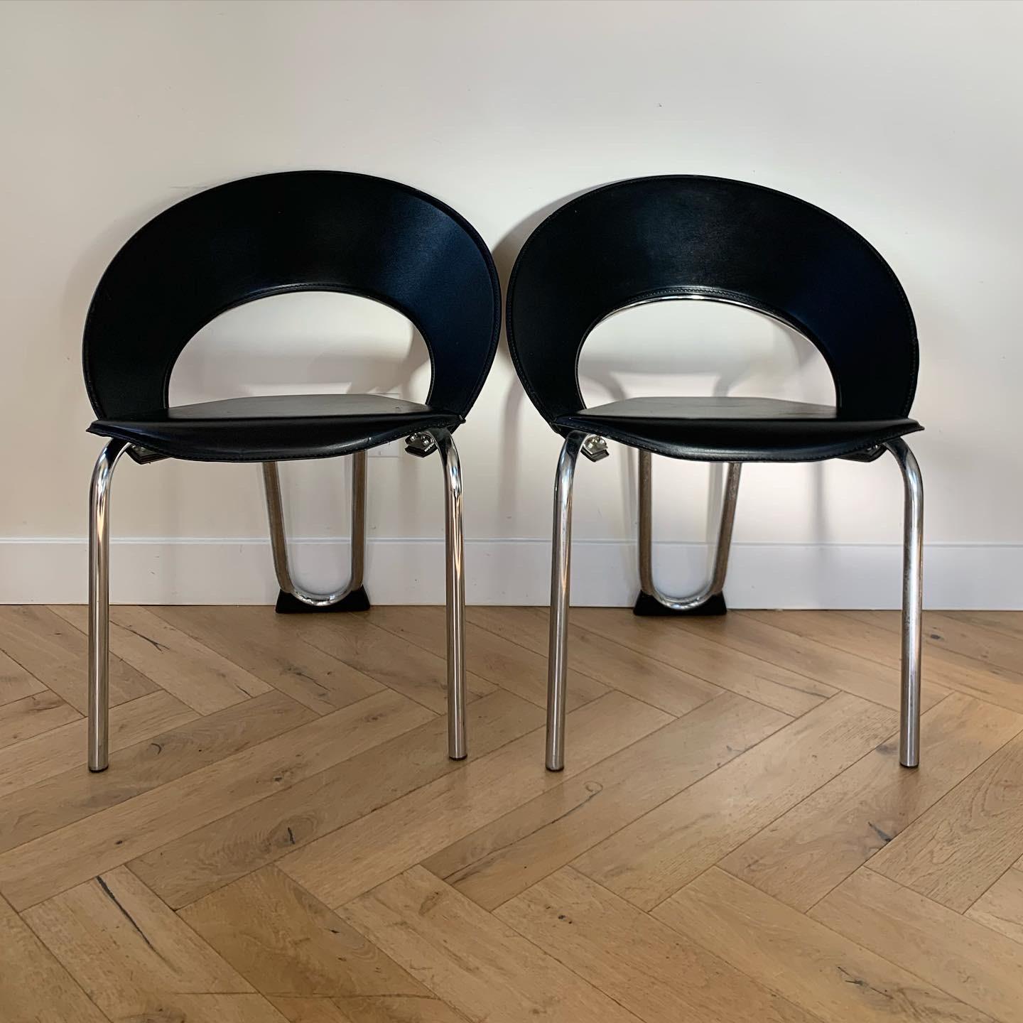 A pair of black leather and chrome Bahauas occasional chairs with thick tubular chrome frames and fanned out backs. Wear consistent with age but overall fab.

Measures: 24” W x 22.5” D x 30” H
Seat: width tapers from 19.5” to 9” x 17.5” depth x 19”