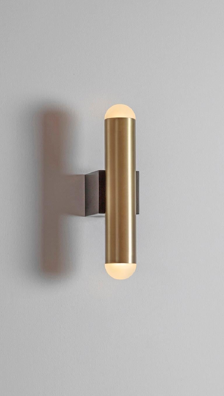 Vector wall lamp by Square in Circle, 2022
Dimensions: W 7 x H 28 cm; projection: 11.5 cm
Materials: Dark bronze, opaque glass, brushed brass


Minimalistic brushed brass wall light with a light source positioned on both ends. The light is