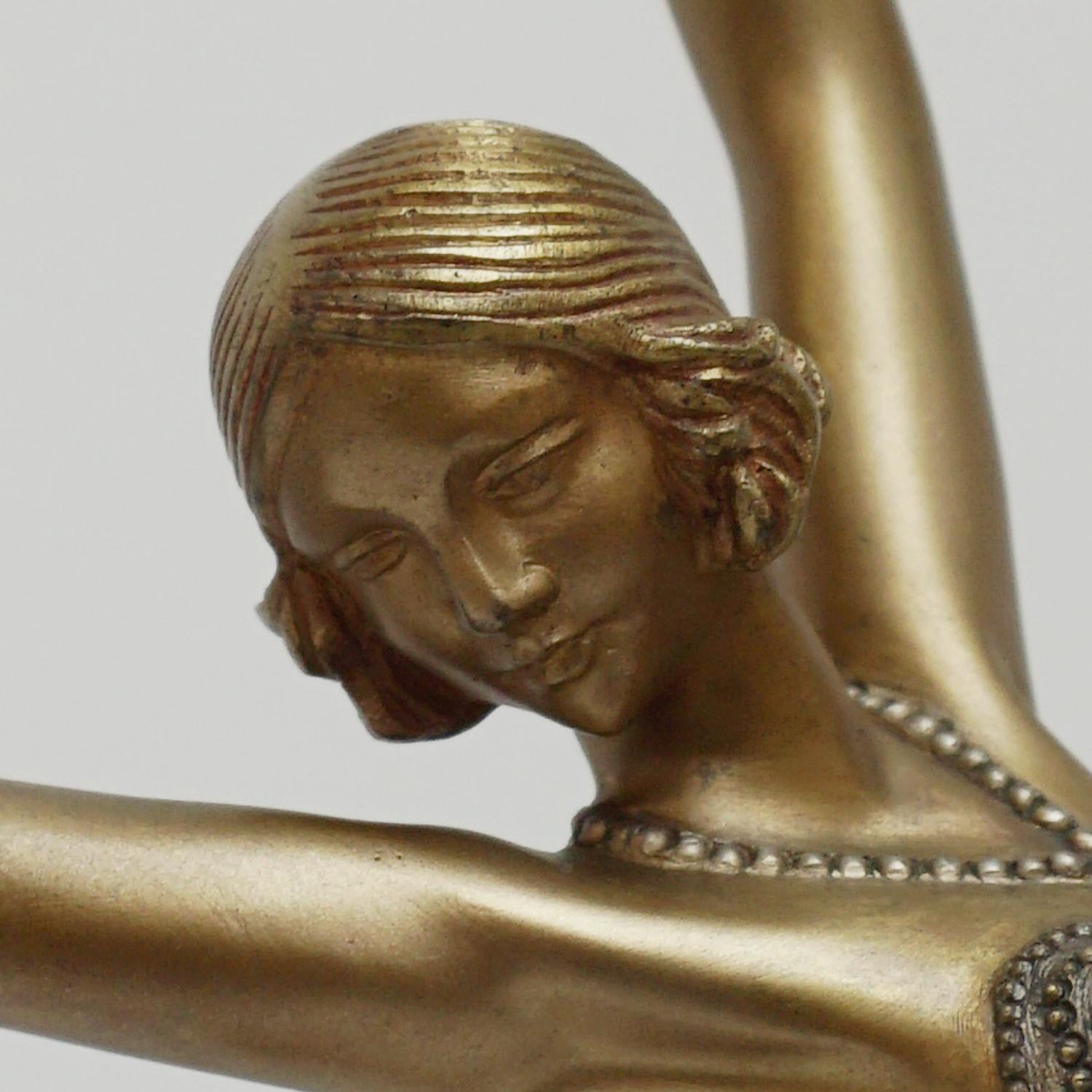 An Art Deco cold painted gilt bronze figure by Demetre Chiparus (1886-1947). An energetic dancer dressed in scantily clad theatrical costume with arms outstretched in a stylised pose. Excellent hand finished detail and Fine colour. Raised on a