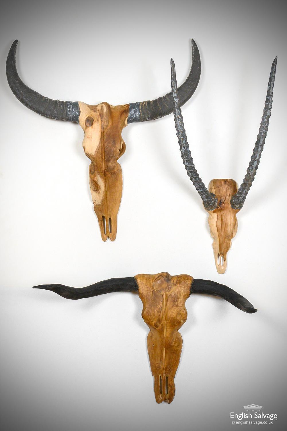 'Vegan' carved teak animal heads or skulls. Flat horned wildebeest skull sold. Bull horns measure: 76cm x 49cm x 37cm deep. Antelope horns measure: 72cm x 36cm 25cm deep.

   