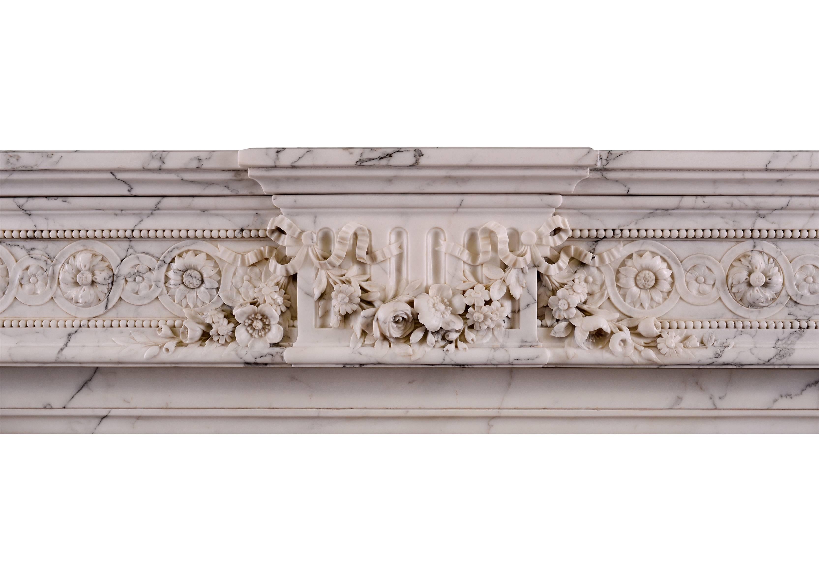 A fine quality 19th century, circa 1830 French Louis XVI fireplace in veined Statuario marble. The frieze carved with flutes, exquisitely carved to the centre with fruit, flowers and ribbons. The acanthus leaf jambs with rope moulding below,