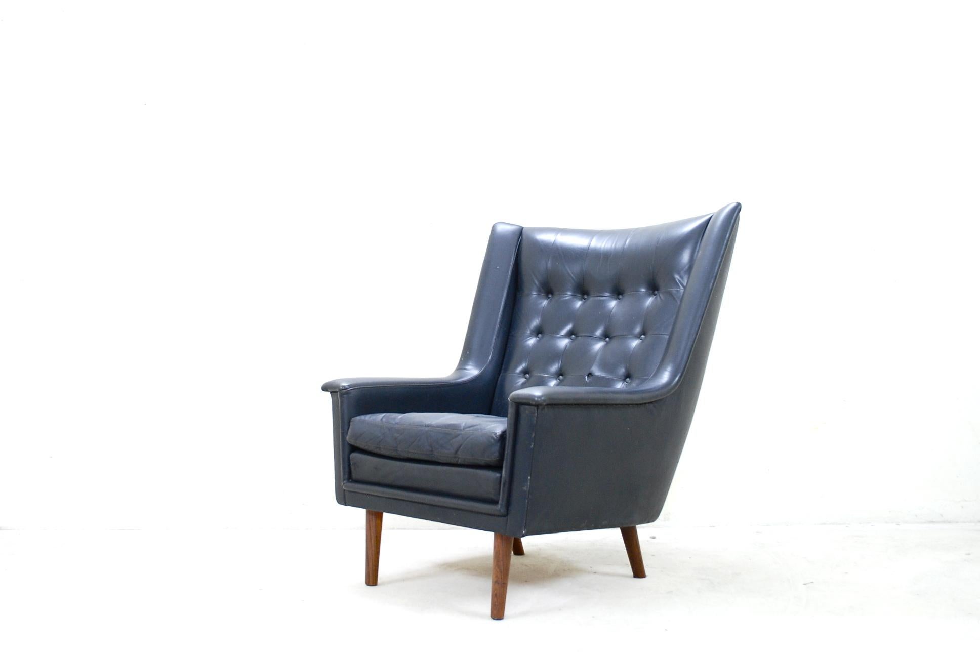 This wingback armchair is manufactured by Vejen Polster Mobelfabrik.
It comes from Denmark and has references to the Wegner Papa Bear chair.
Black leather and afromosia wood.