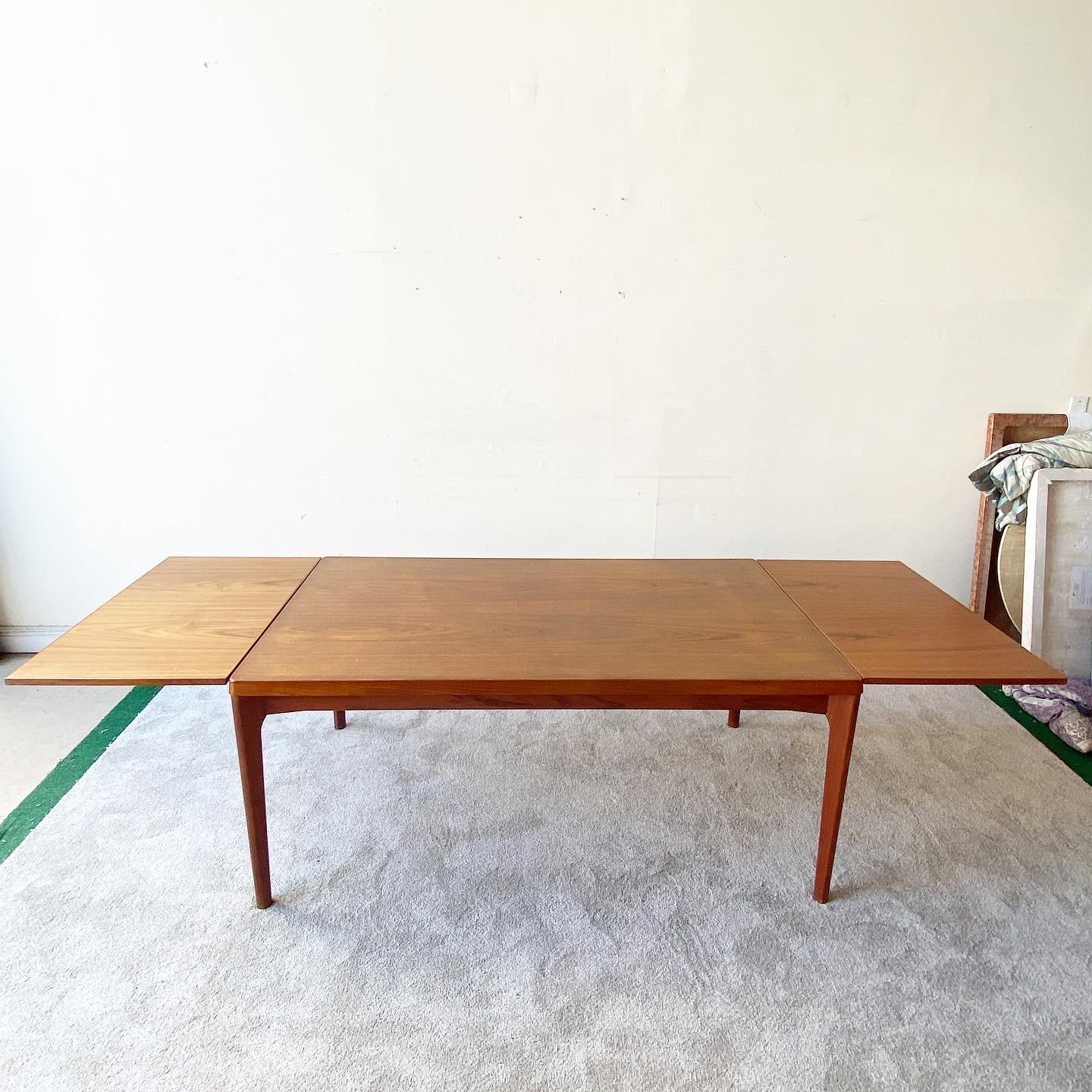 Outstanding vintage Scandinavian Modern teak veneer extension dining table by Henning Kjaernulf for Vejle Stole Mobelfabrik. Features two extension leaves which slide out from underneath the table top. Circa, 1960’s.

Two leaves. Each leaf