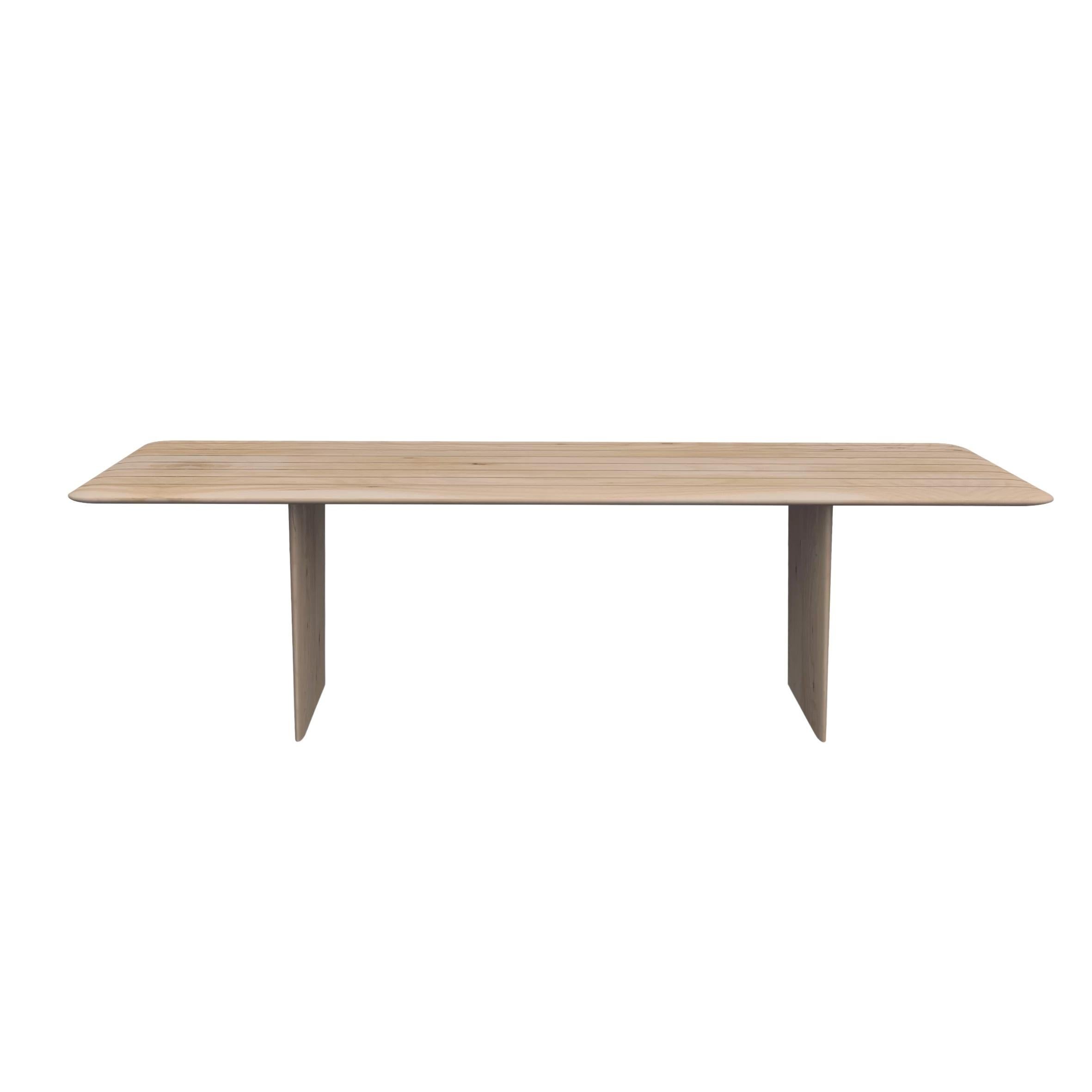 Realizzato interamente in legno massiccio di cedro profumato, questo tavolo presenta lati arrotondati e sottili bordi smussati sia sul piano che sulle gambe, conferendogli un design delicato e sinuoso. La sua leggerezza è accentuata dall'uso