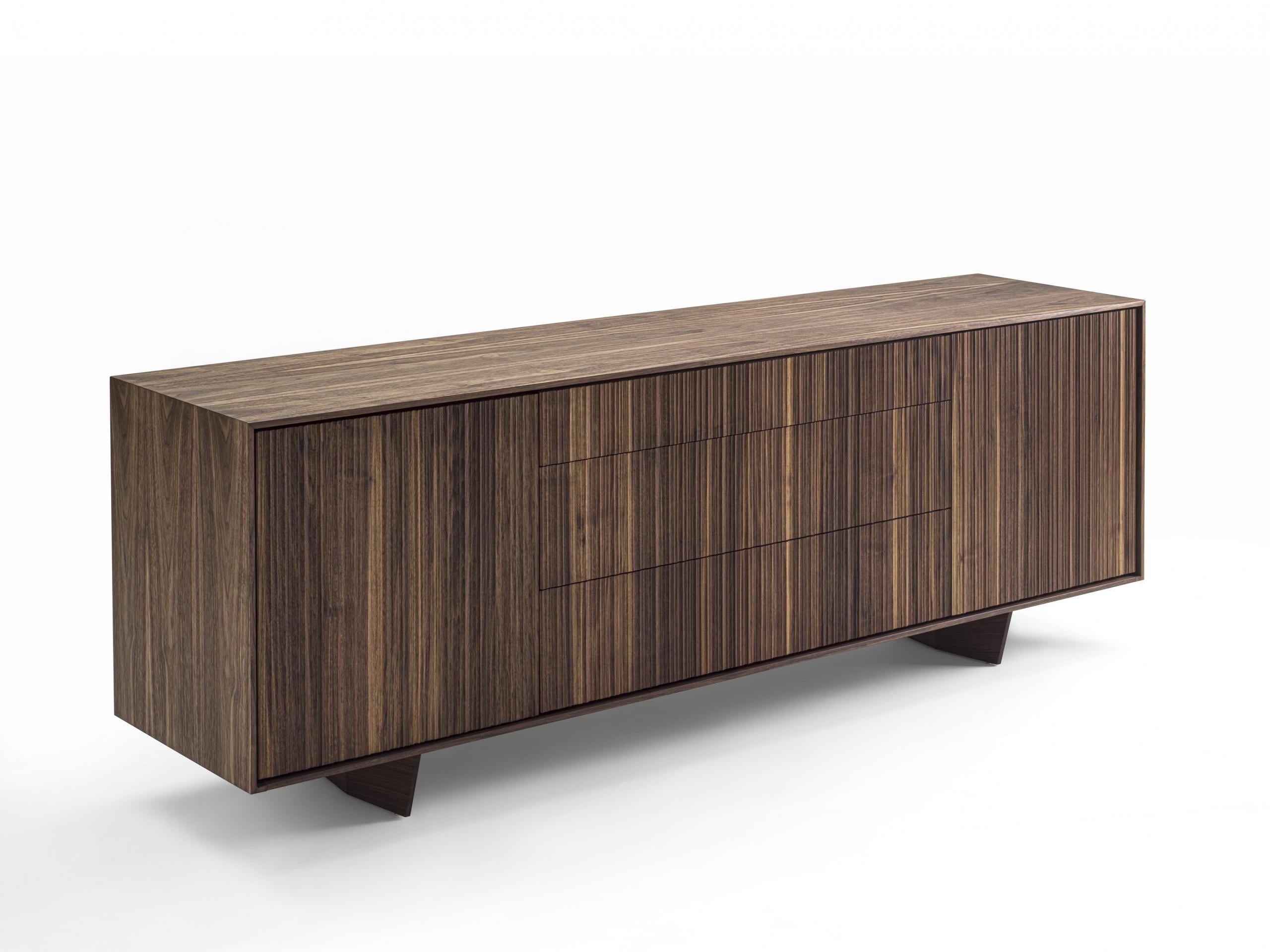 Sideboard made of solid wood and blockboard, characterized by a particular vertical processing of doors and drawer fronts that creates a modern and dynamic geometric effect. Drawers assembled with dovetail joints.

Available in Walnut, Cherry,