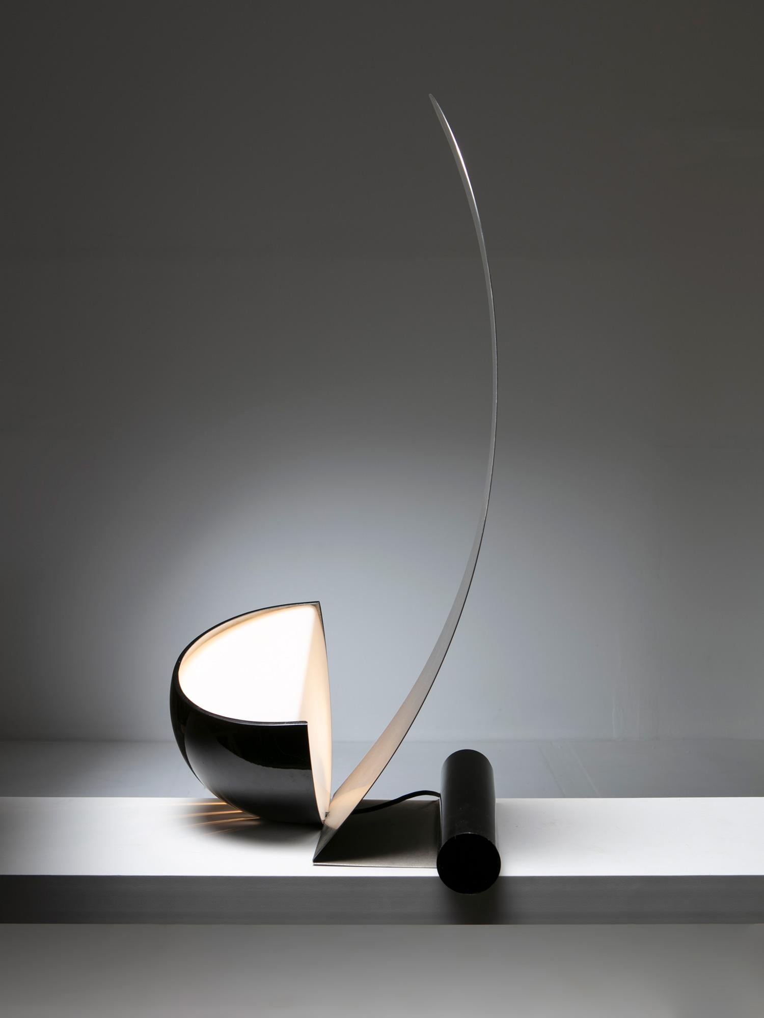 Sculptural Vela table lamp by Werner Krieger for Prestige.
Steel shade reflecting the hidden light source hidden in the black metal shell.