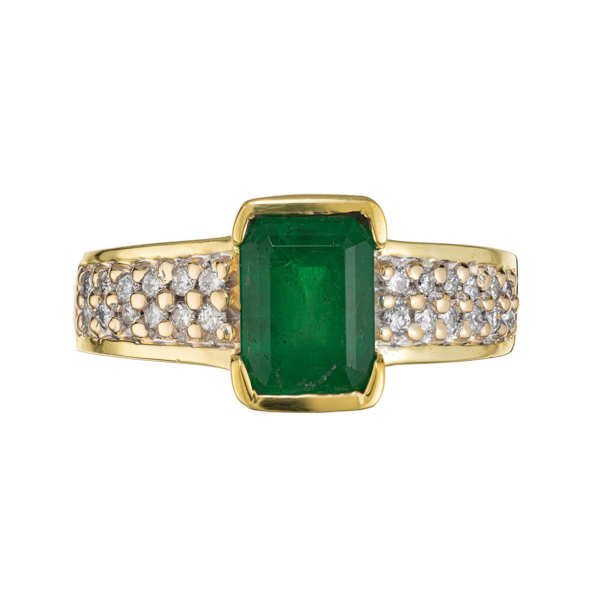 Green emerald and diamond engagement ring. GIA certified rich green octagonal cut 1.63ct emerald which is semi bezel set in a 14k yellow gold setting. Each shoulder has 2 rows of round brilliant cut diamonds. GIA certified this emerald as, natural