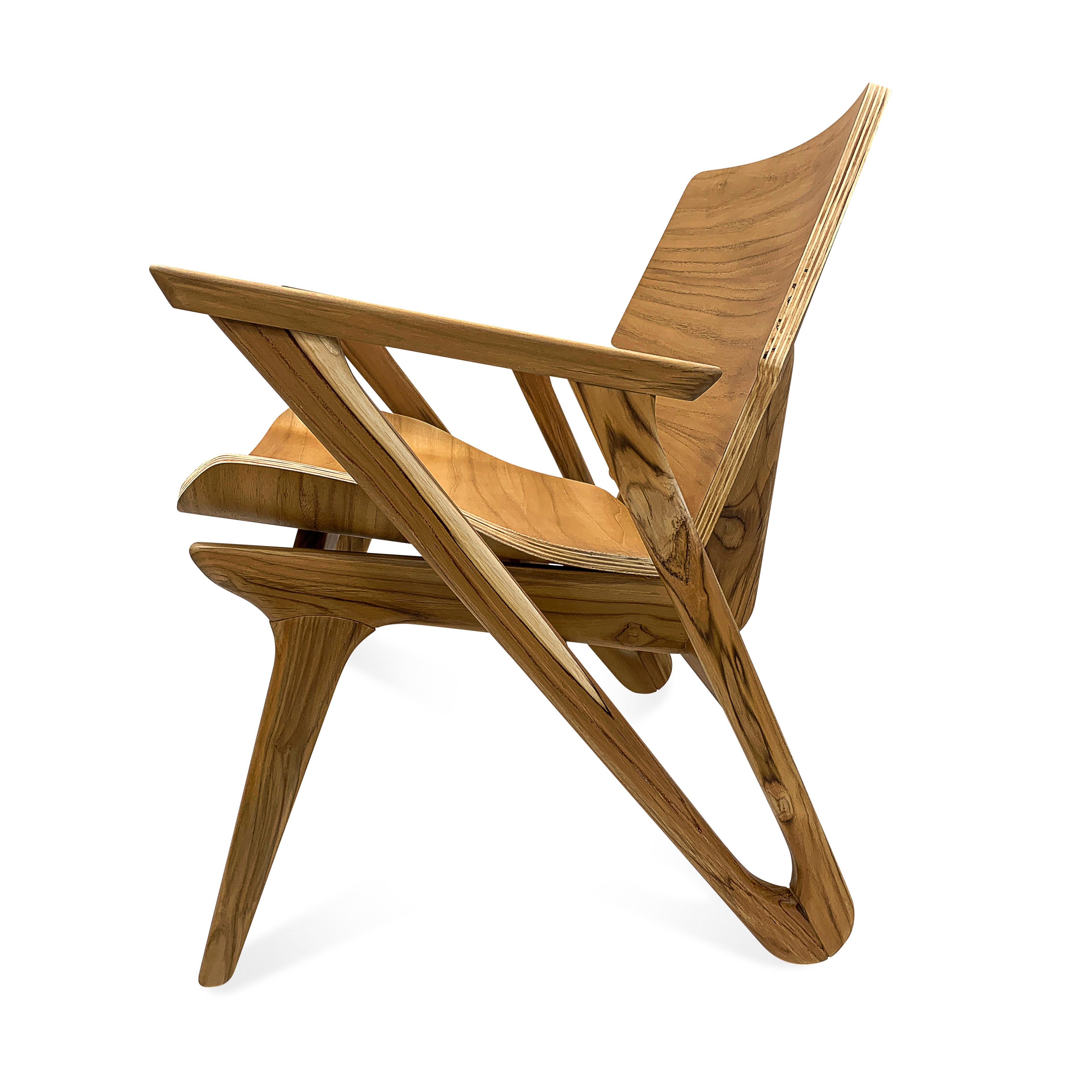 Ce fauteuil minimaliste Velo avec une assise et un dossier en forme, présente un design simple et épuré, avec des formes géométriques et une assise incurvée avec un coin doux et fort qui met l'accent sur la simplicité et la fonctionnalité dans une