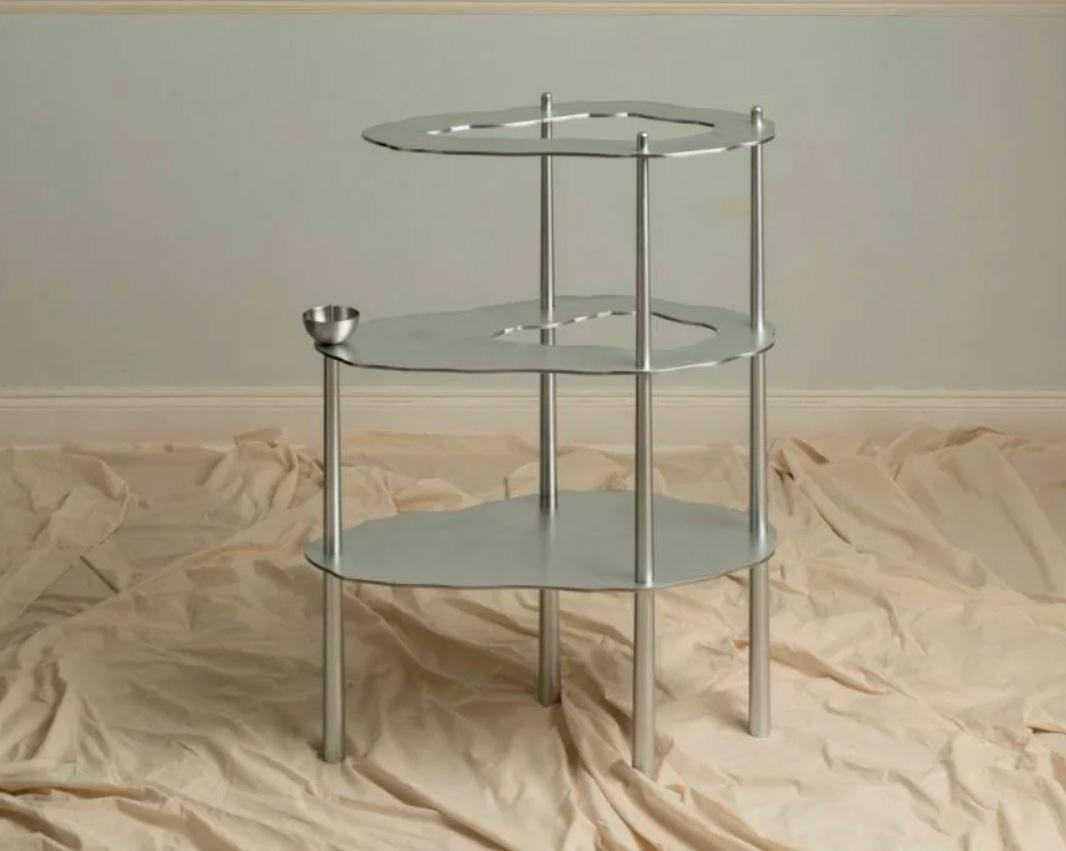 Velora est le nom d'une sculpture fonctionnelle en aluminium qui explore la tension entre la légèreté et la solidité, entre le domestique et le cosmique. Telle une ruine élégante d'un futur qui n'est jamais arrivé, la pièce est ancrée dans la