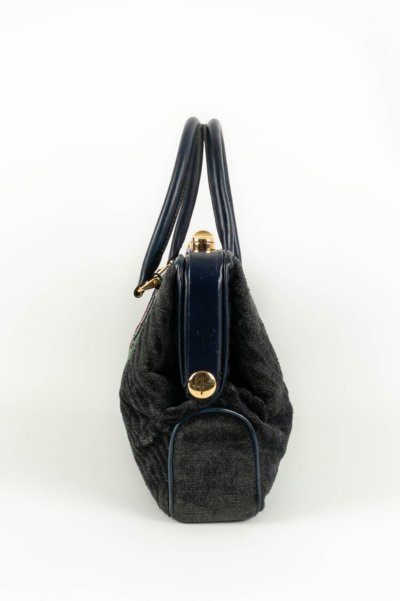 (Made in France) Velvet and dark blue leather bag. Canvas interior. To note, rare marks on the leather.

Additional information:
Condition: Good condition
Dimensions: Width : 39 cm - Height : 22 cm - Depth : 7 cm - Handles : 45 cm 

Seller