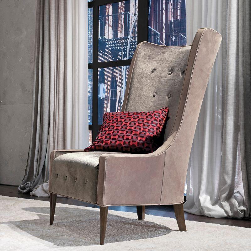 A sumptuous and elegant design, this gorgeous armchair will complement both modern and traditional decors alike. Resting on walnut feet, it is upholstered with gray tufted velvet on the inside and with nab leather on the back. It includes one pillow.