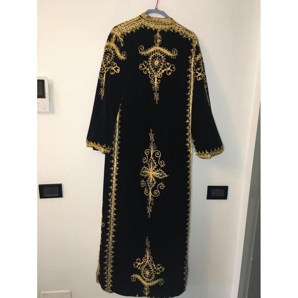 Velvet Coat in Black

Tailored caftan. Oriental style. Very original and elegant garment. 
Missing composition and size label. 
We think it's black velvet with gold embroidery. 
Wearing a 42 it. The shoulders measure 42 cm, the bust 50 cm, the