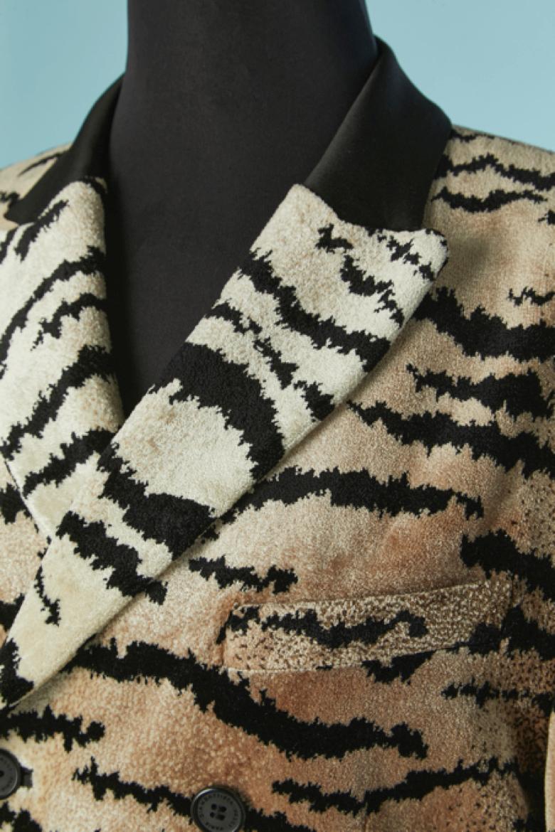 Chaqueta de terciopelo de doble botonadura con estampado animal y cuello de raso negro. Composición del tejido principal: 70% rayón, 30% poliéster. Forro de rayón con la marca. 3 bolsillos exteriores y 4 interiores. Hombrera. Botón con la marca y
