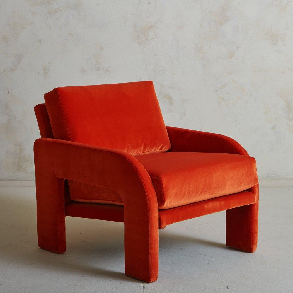 A stately lounge chair designed by Adrian Pearsall for Comfort Designs in the 1970s. This piece has two cushions and was freshly reupholstered in a deep orange velvet. We love the curved arms and sculptural profile on this timeless lounge chair.