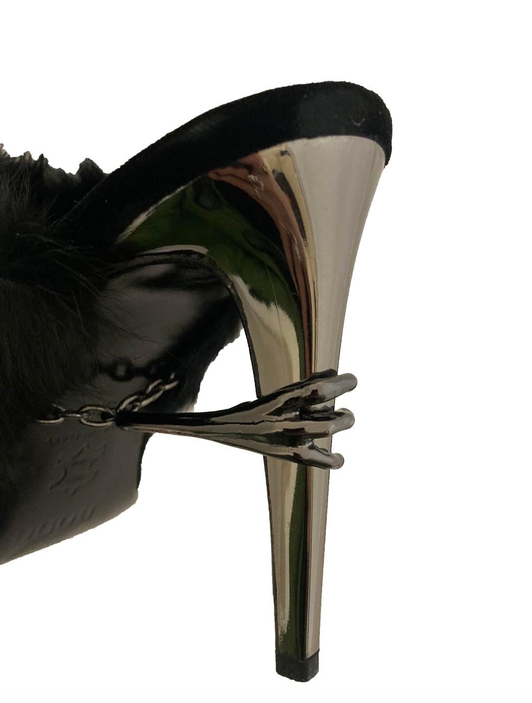 Black velvet Raven mules from Rodo. Super pointed, elongated toe in black velvet with a black faux fur trim around the opening of each mule. Backless, strapless, slip on style with an 11cm shiny pewter toned metal heel gripped by a metal ravens claw