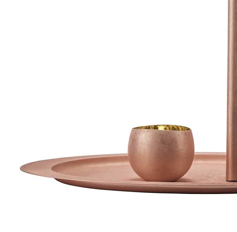 A work of understated elegance, this lavish drink and tray set elevates serveware to art. This work is handcrafted of hammered copper resulting in a soft-to-the-touch surface texture. The simple geometries of the oval tray and sleek design of the
