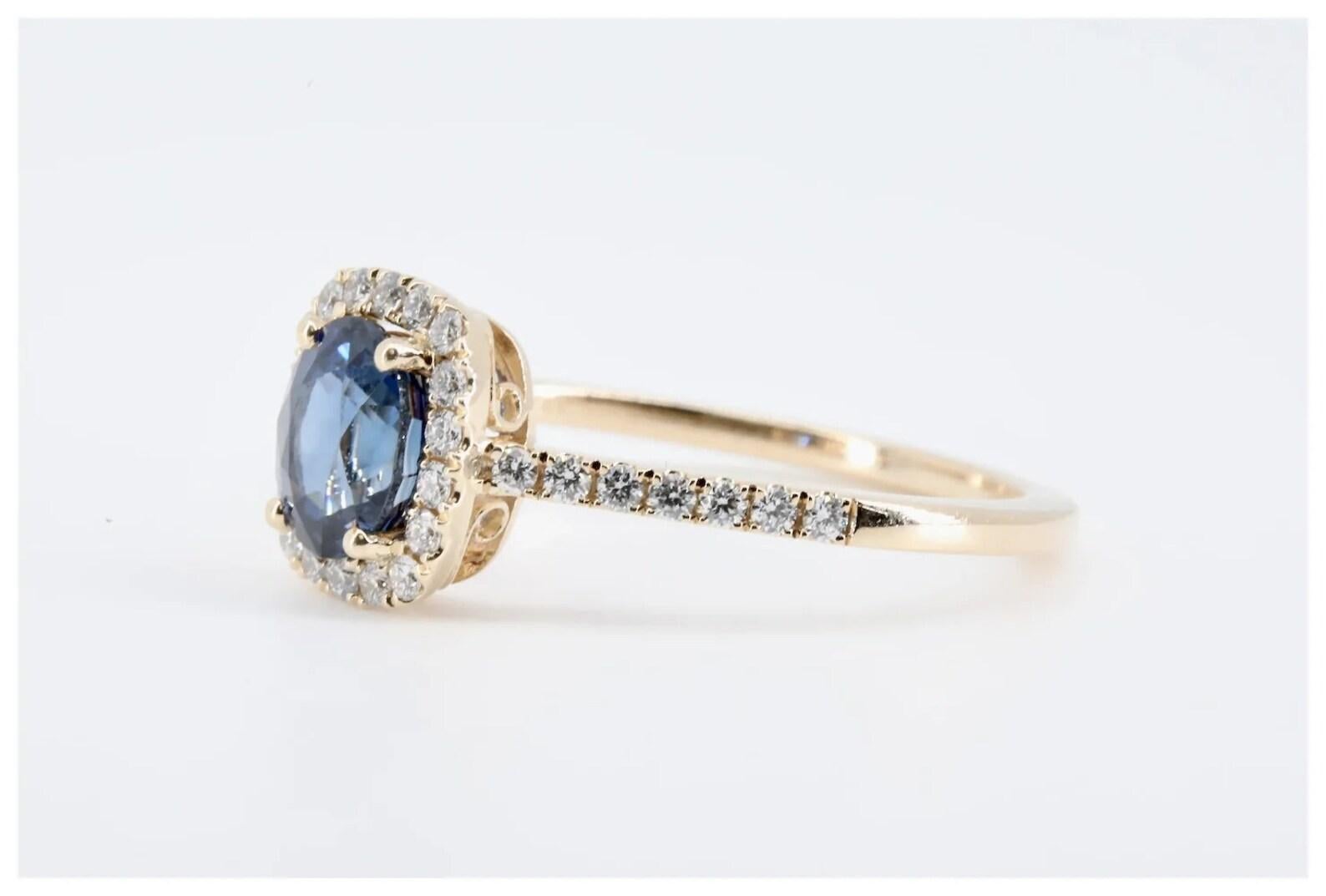 A velvety blue sapphire, and brilliant cut diamond halo engagement ring in 14 karat yellow gold.

Centered by a 1.20 carat cushion shaped blue sapphire, heat treatment only.

The mounting accented with 0.24 carats of brilliant cut diamonds