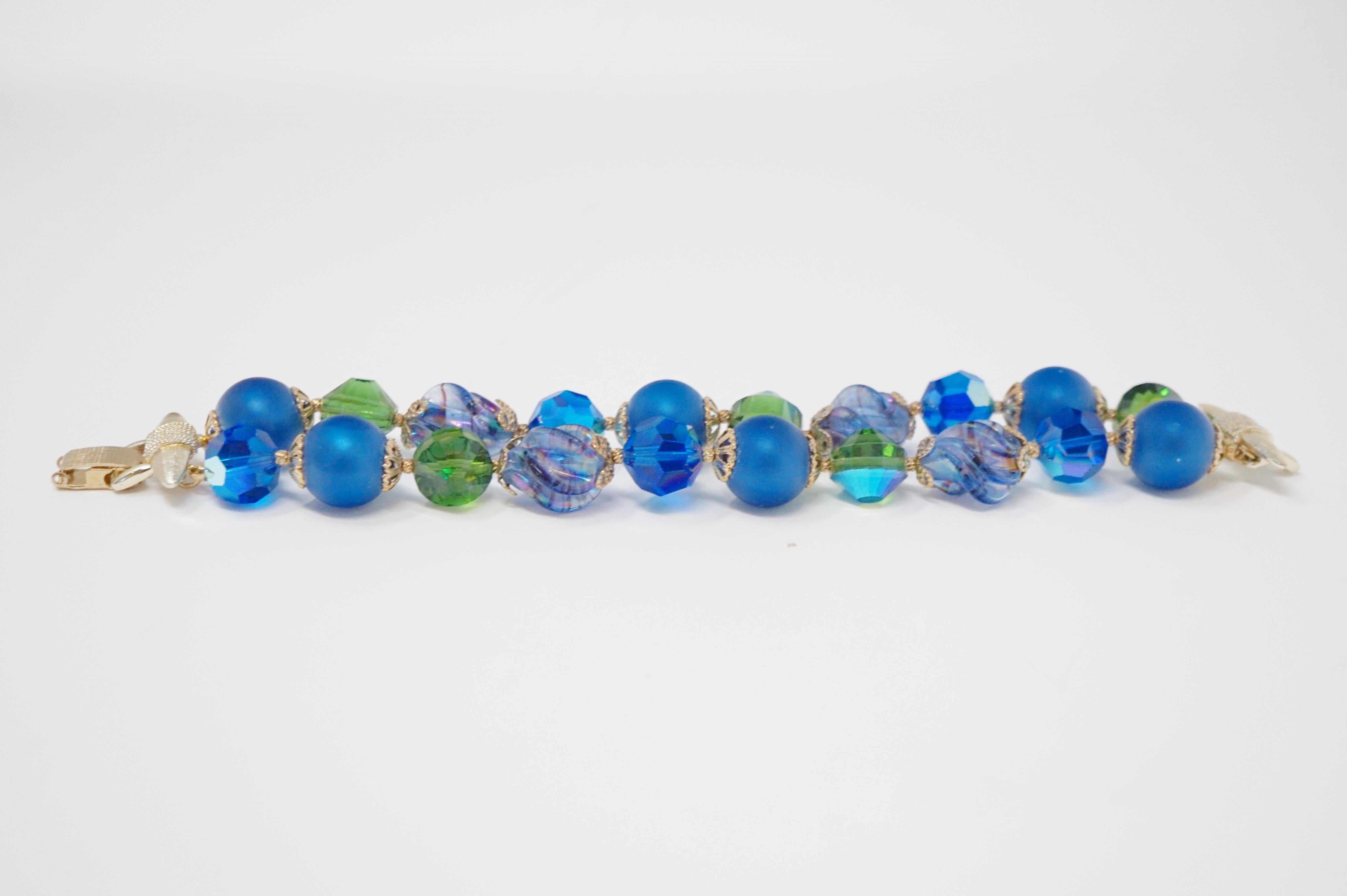 This exquisite double strand beaded bracelet by Vendome features a mix of matte cobalt blue beads, mercury glass beads and Aurora Borealis iridescent crystal beads with gold tone accents. Signed Vendome on gold tone clasp.  

Operated as a