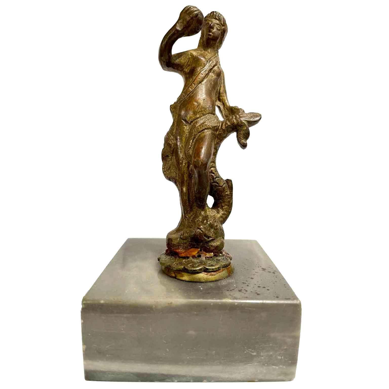 Vénus au dauphin en bronze 1600, une petite sculpture italienne du 17e siècle se terminant par une pointe à la base. Il tient une sphère dans sa main droite et la queue du dauphin dans sa main gauche. Le moulage n'est pas défini à l'arrière, de