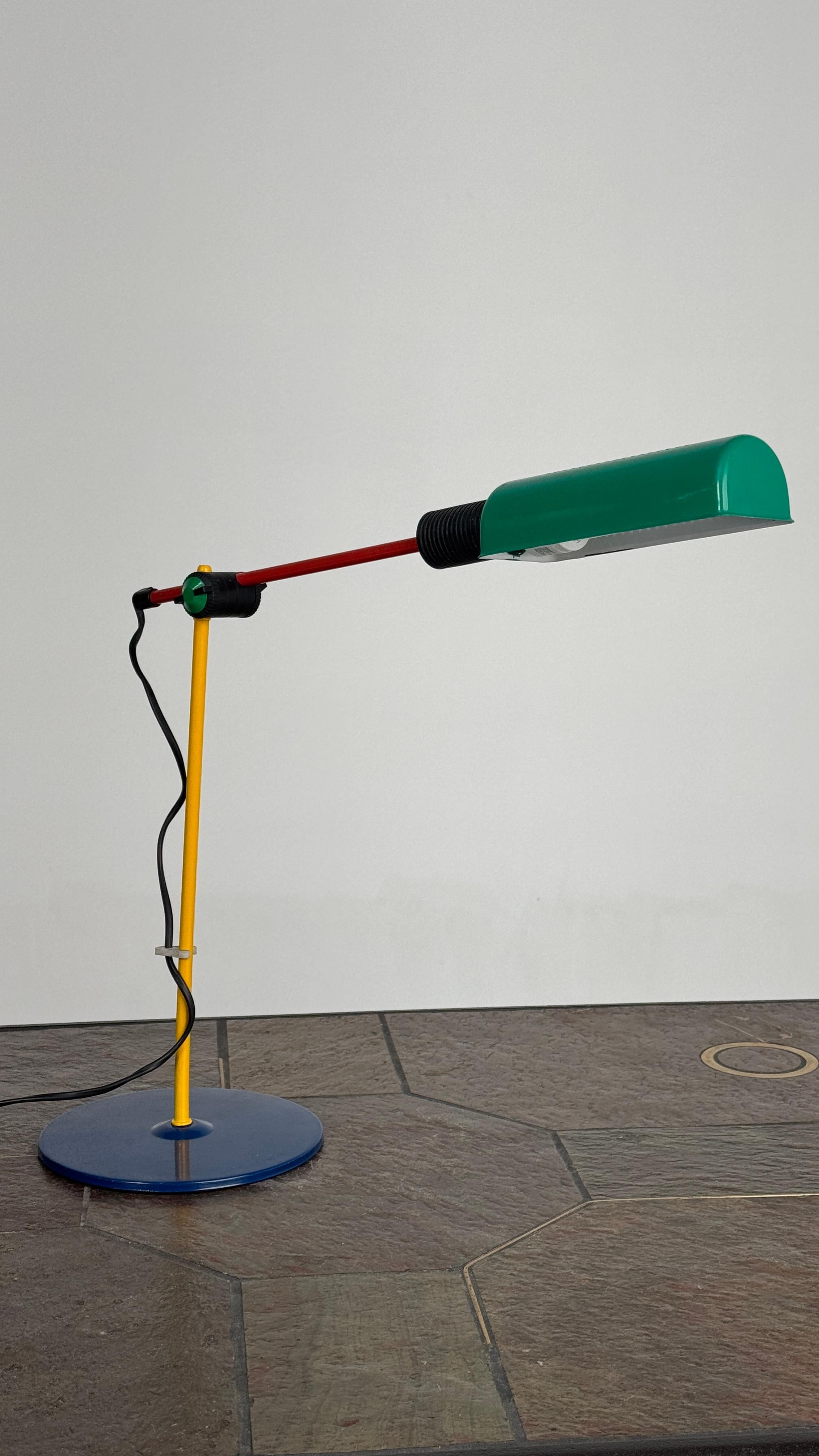 🎨 Veneta Lumi stolna lampa - prava poslastica za ljubitelje postmodernog dizajna!
Ova lampa u duhu Memphis grupe donosi eksploziju boja i hrabru geometriju - plava baza, žuto telo, crveni krak i zeleni abažur stvaraju neponovljivu vizuelnu igru.