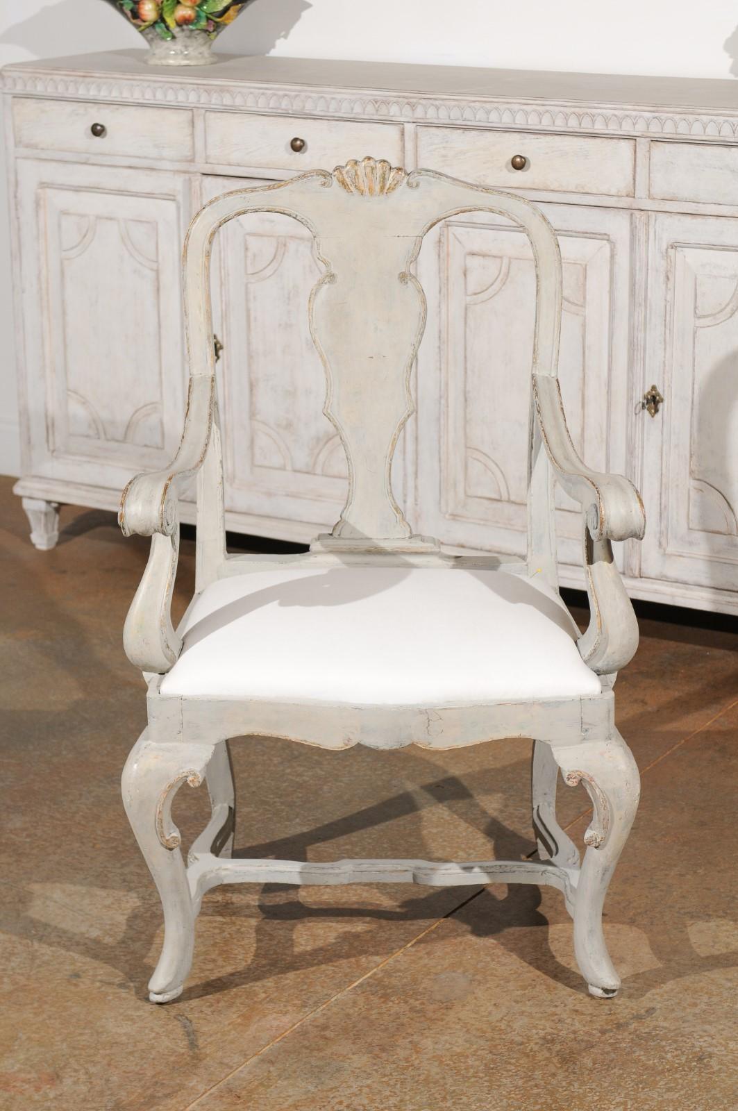 Ein italienischer Rokokosessel aus bemaltem Holz aus dem frühen 19. Jahrhundert, mit geschnitztem Sims, geschwungenen Armlehnen, Cabriolehnen und Kreuzstrebe. Dieser exquisite, bemalte Sessel, der in den ersten Jahren des 19. Jahrhunderts in Venedig