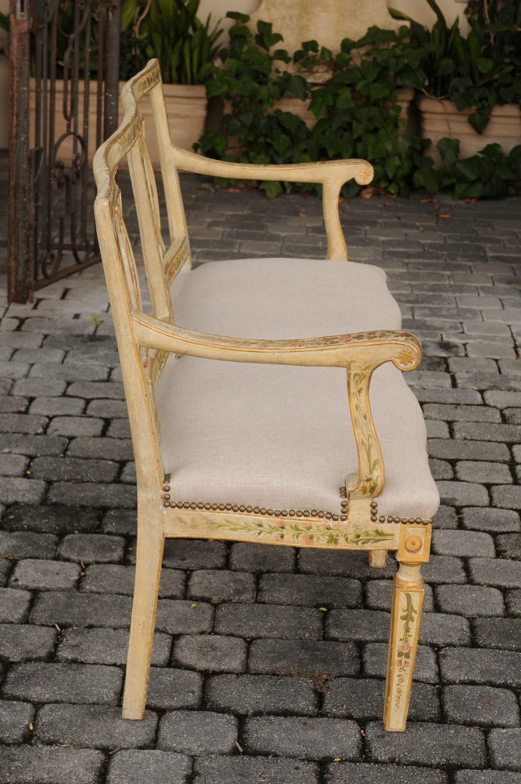 An Italian painted wood settee from the late 19th century, with floral décor and new upholstery. Born in the Serenissima during the last quarter of the 19th century, this Venetian settee features a slightly slanted open back with serpentine rail,