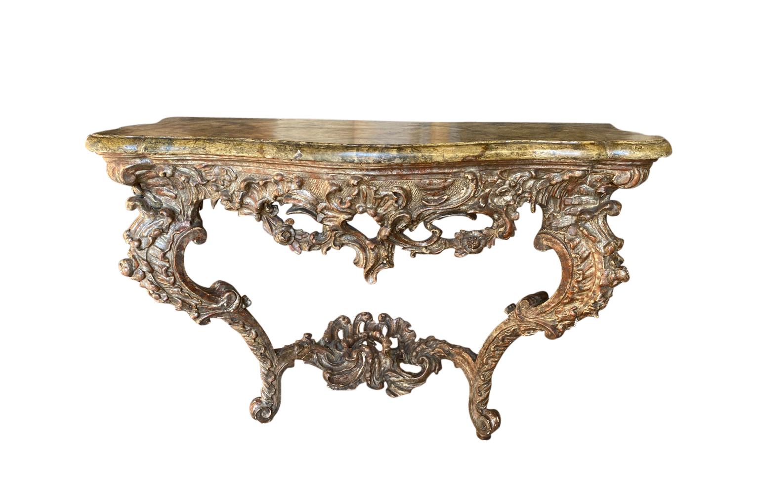 A sensational 18th century Baroque Venetian console. Beautifully constructed in giltwood in the Mecca technique - the mixing gold and silver gilt with an outstanding faux marble top. A truly stunning piece.