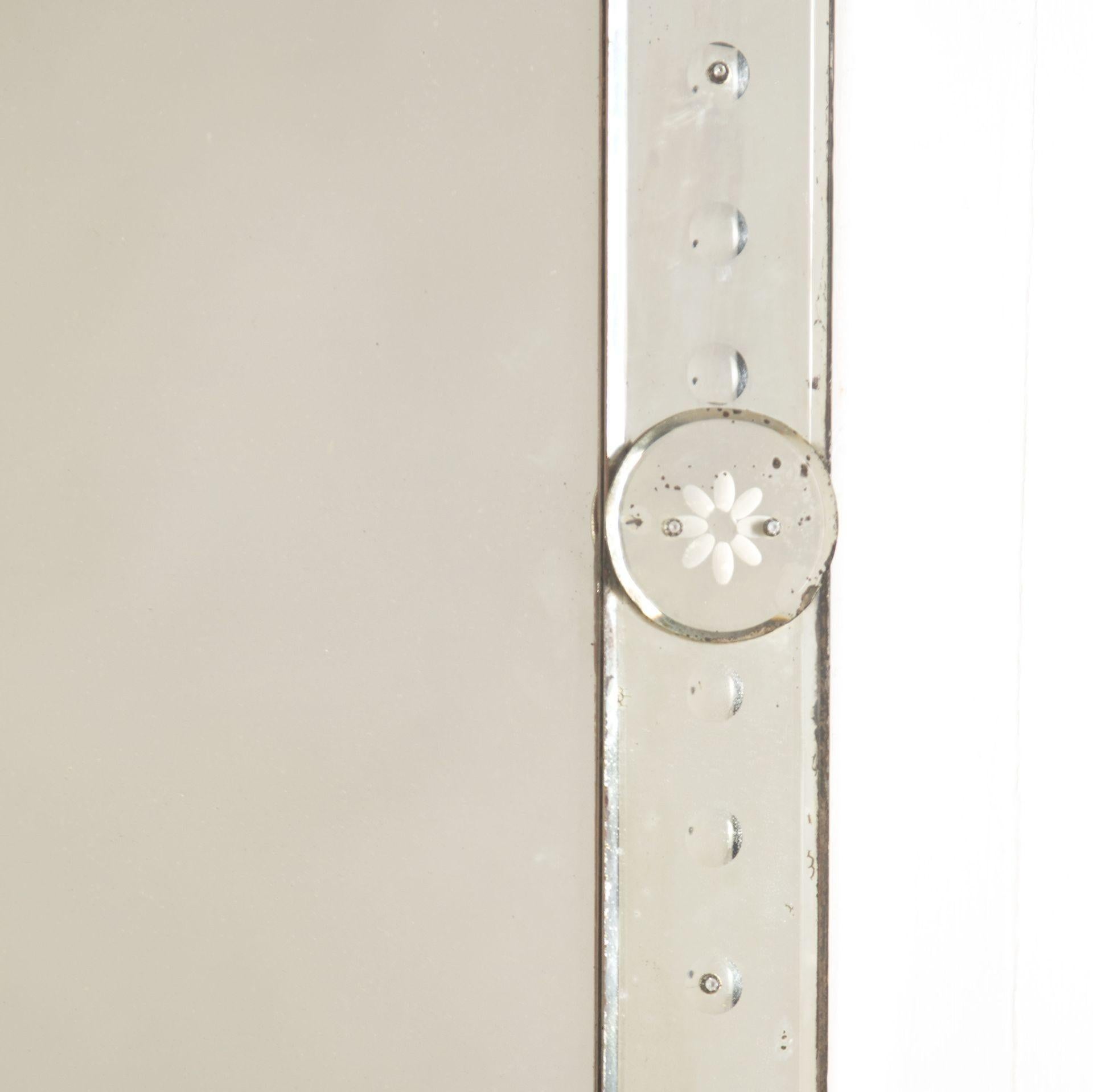 Stunning 19th Century Venetian bistro mirror.
This beautiful French mirror features a foxed glass plate that is encased within a bubble glass border.
Set within two of the bubble glass details are small engravings of flowers, these add to the