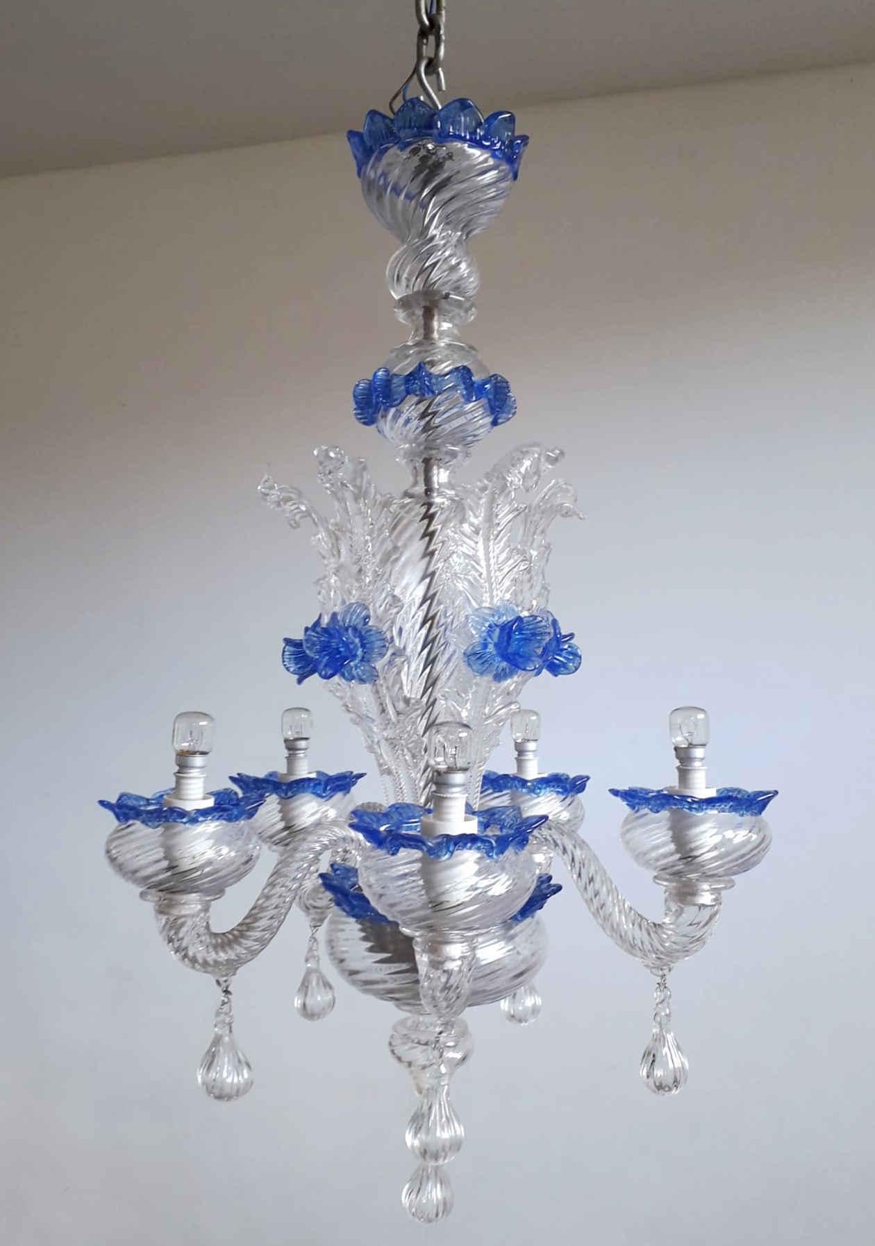 Ornate vintage Italian Murano chandelier with hand blown clear ribbed glass body, leaves and droplets, decorated with blue flowers and accents / Made in Italy circa 1950s
Diameter 16 inches, height 25 inches
5 lights / E12 or E14 type / max 40W