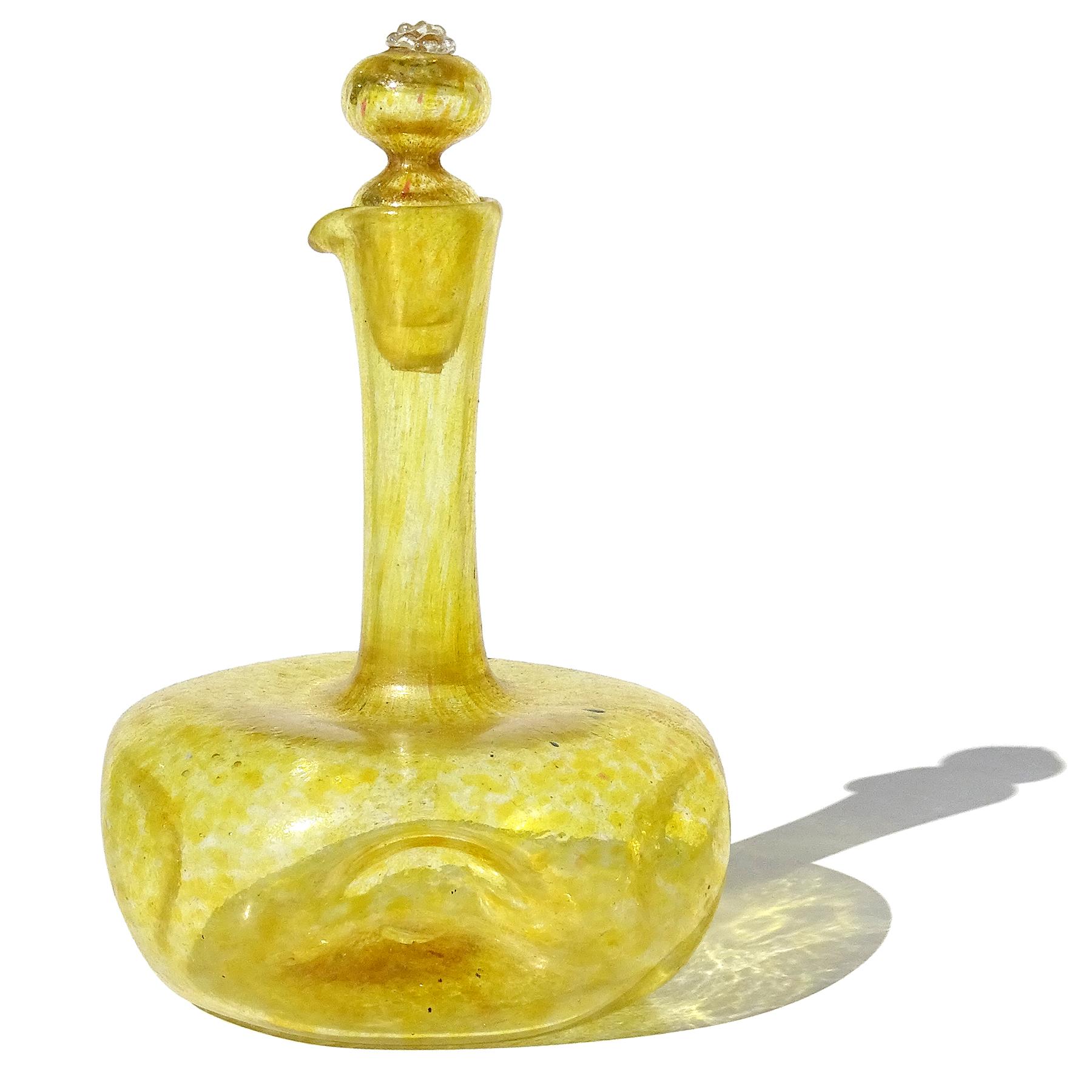 Magnifique burette en verre d'art italien soufflé à la main, jaune et mouchetures d'or, avec bouchon d'origine. Attribué à la serre de la Compagnia Di Venezia E Murano (C.V.M.). La bouteille a une forme arrondie, mais elle est alvéolée de chaque