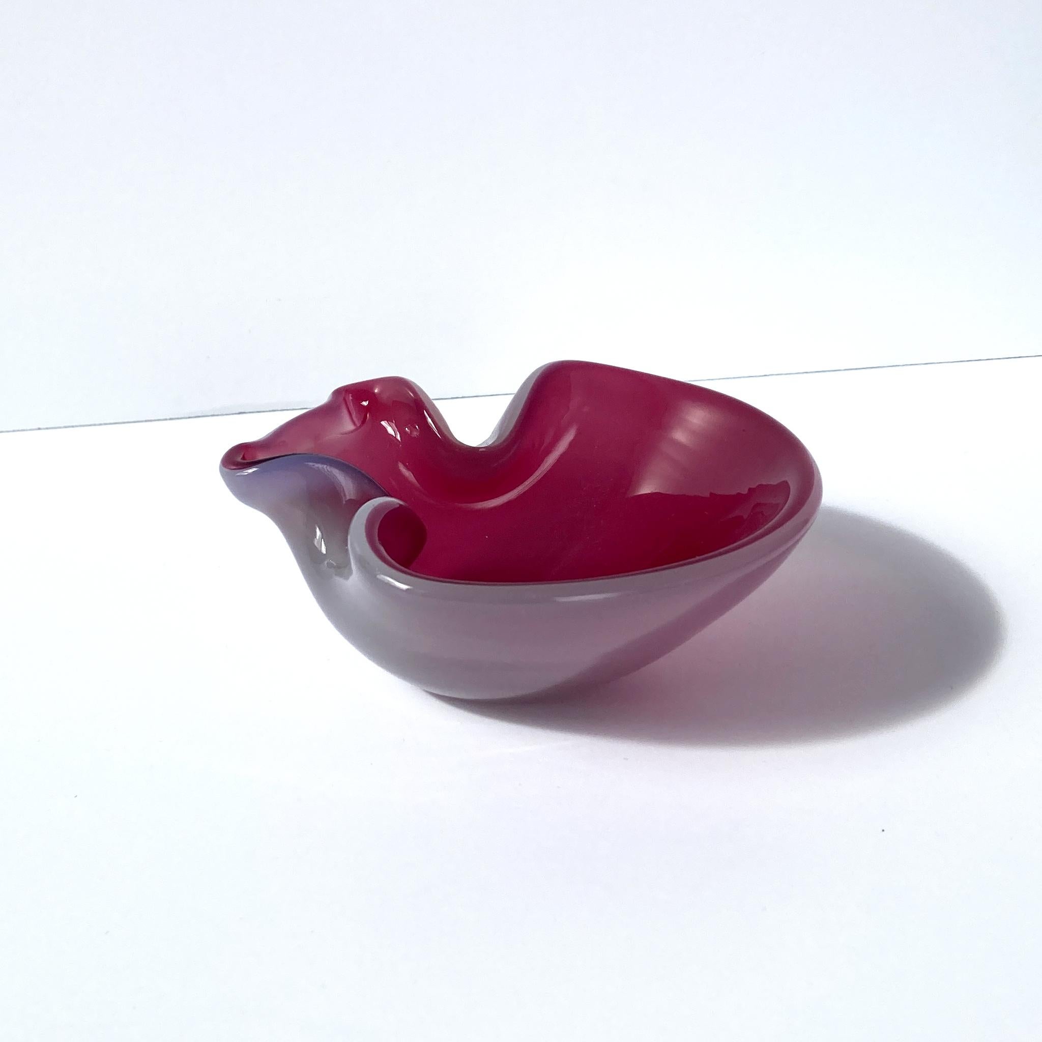 Stunning, unique Venetian hand blown art glass vide poche. Beautiful cranberry pink interior with light pink opal exterior, creating a luminous mauve shade. The glass glitters when the light hits this piece at different angles. Abstract shape lends