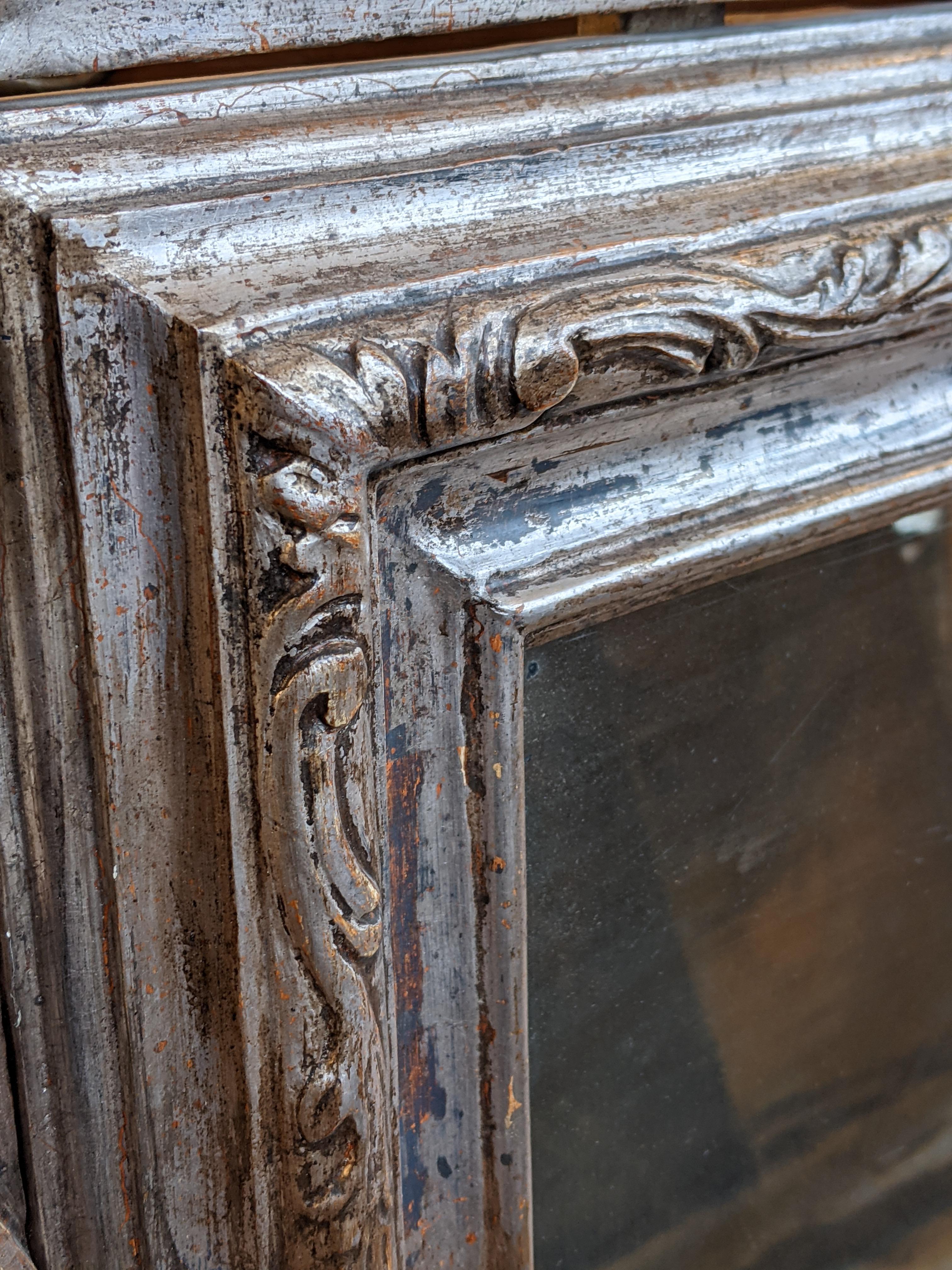 Venetian mirror from the early 1800s in Baroque style. The frame is in wood covered with silver leaf, the mirror is original of the time.
Can be used both as a console mirror and as a wall mirror.

Please note that all of our items are shipped