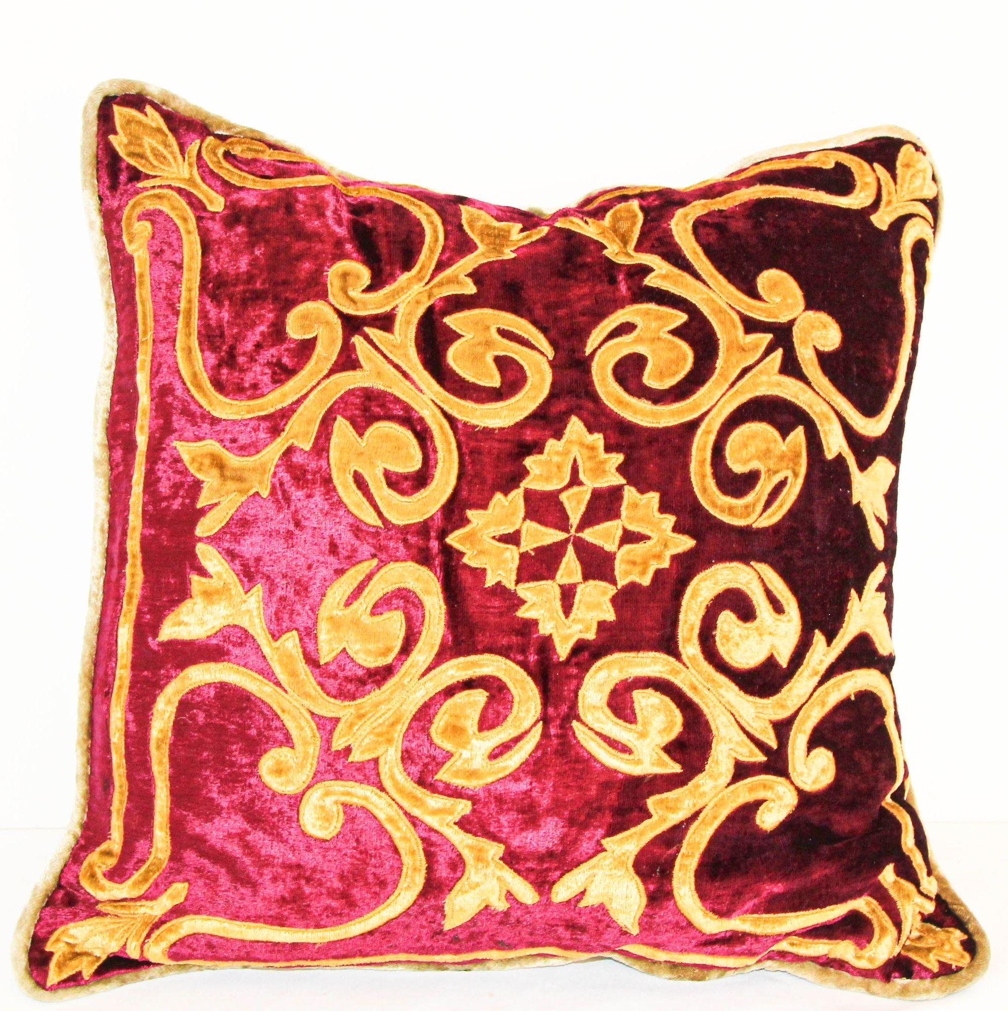 red pillow with gold tassels