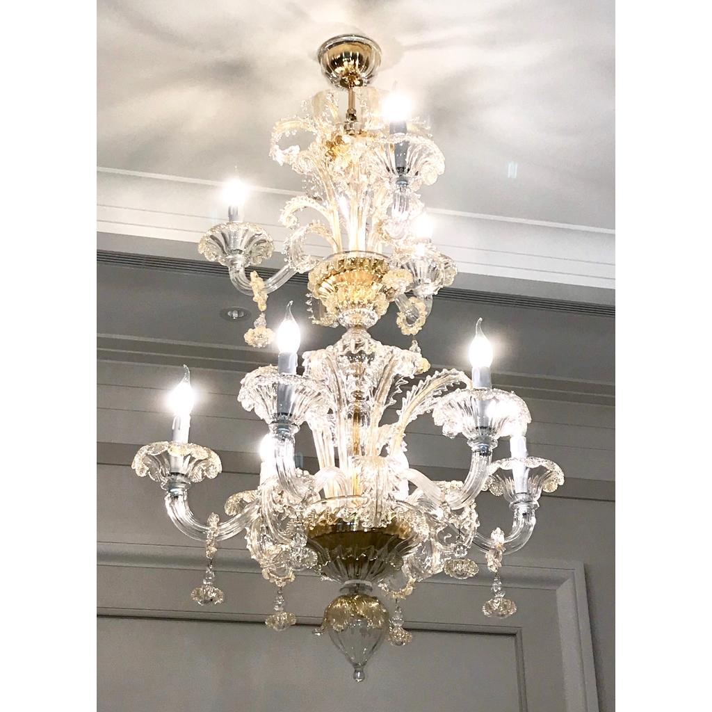 This contemporary Italian chandelier, entirely blown and handcrafted in Italy, in Baroque Rezzonico style, is a high-quality Art Work, in crystal clear Murano glass highlighted by 24-karat pure gold accents. It is composed of 2 tiers, the lowest one