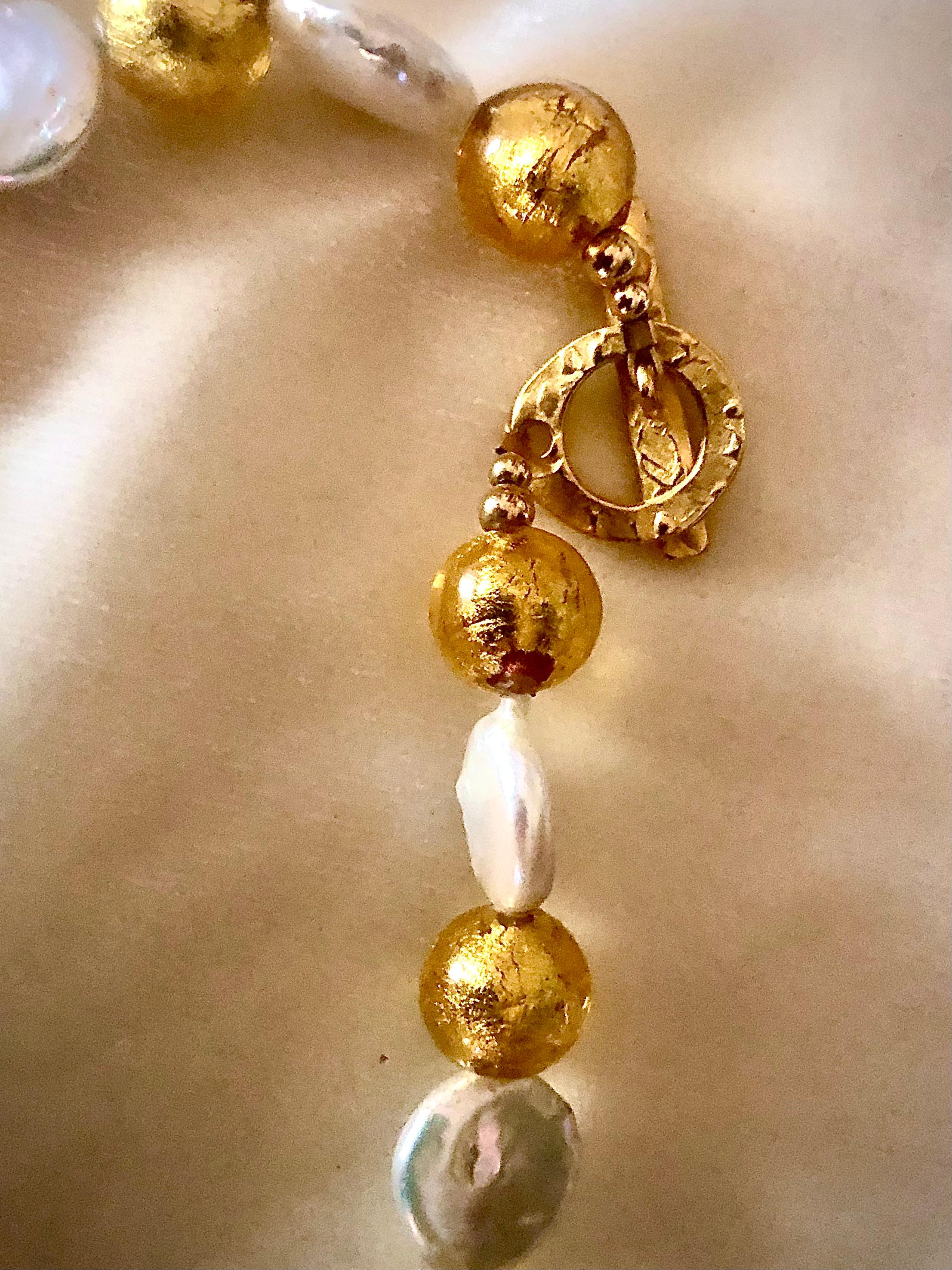 Bright and extremely pretty necklace. The piece is composed of lustrous coin pearls alternating Venetian handmade glass beads. The golden beads are composed of round beads alternating with Maltese cross shapes.

These handmade beads are clear with