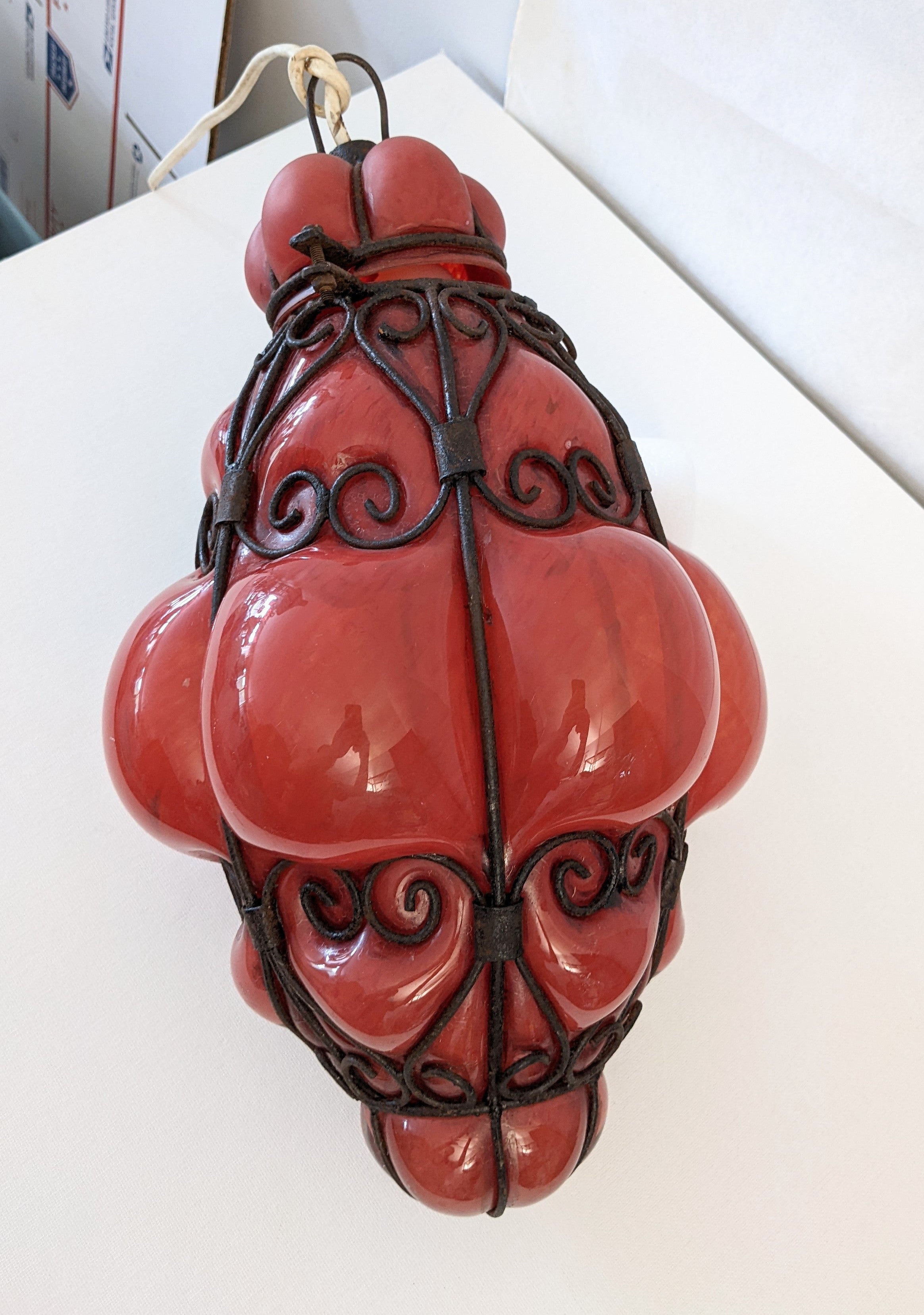 Une belle lanterne vénitienne vintage soufflée à la main en verre marbré orange dans un cadre en fer forgé, Italie, années 1930. Ce pendentif procure une chaude lueur rose orangée et convient à un usage intérieur et extérieur. 
Nécessite une chaîne